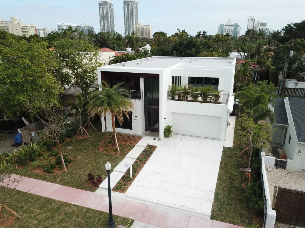 Aerial view of modern white residence with wood cladding and rooftop terrace in Miami Beach