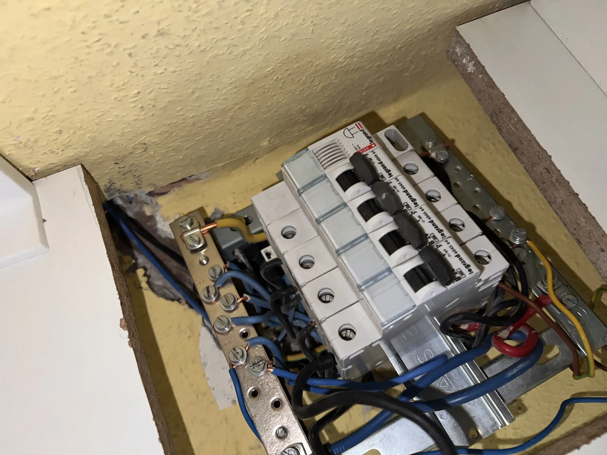 Regi biztositekszekreny elavult olvadobiztositekokkal es digitalis villanyoraval falra szerelve