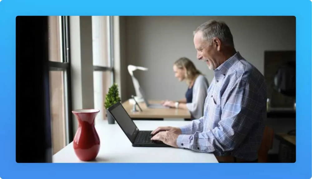Profile of an older tech professional on a laptop excited with the benefits of a new career