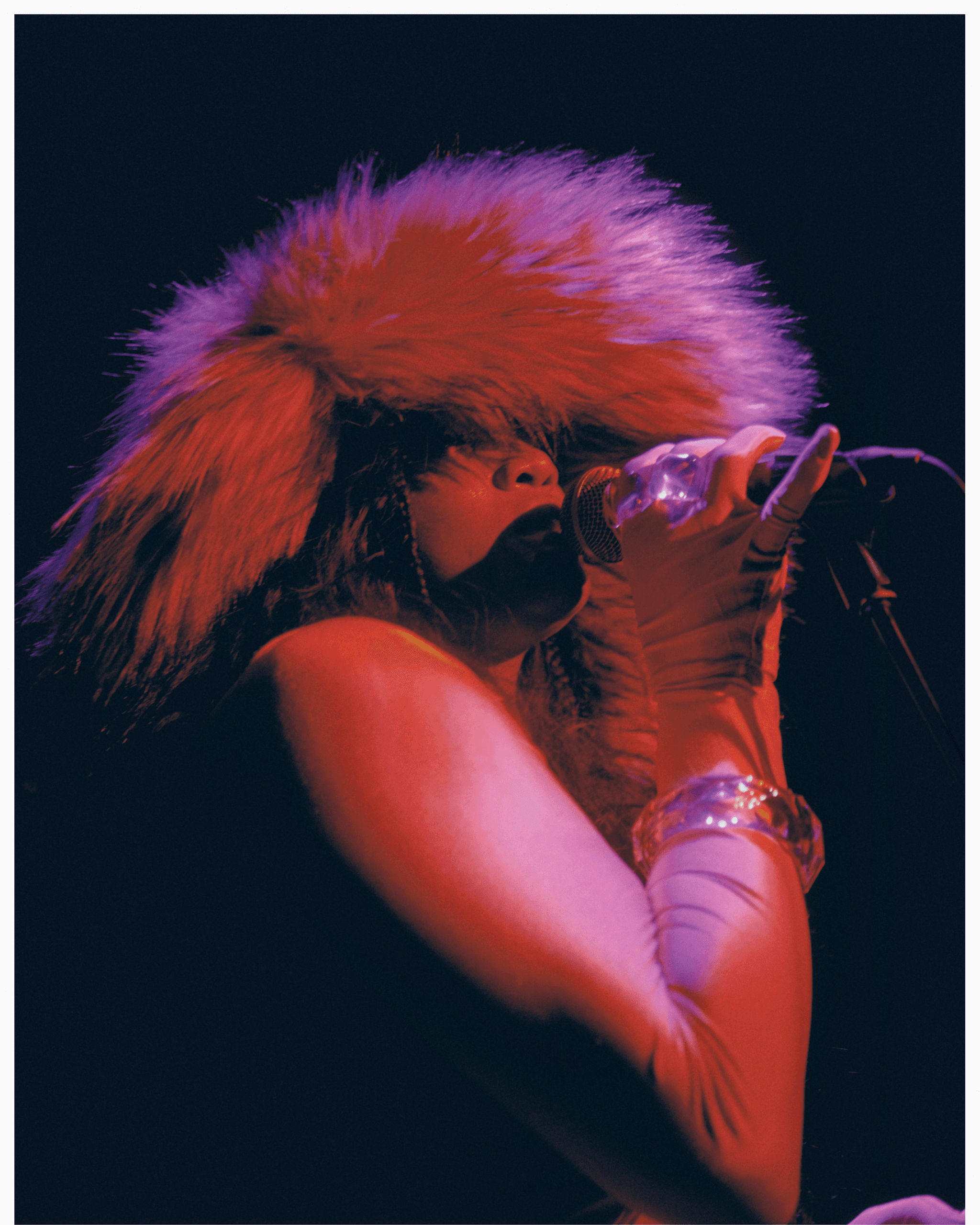 Young woman with dark hair and bangs, wearing red.