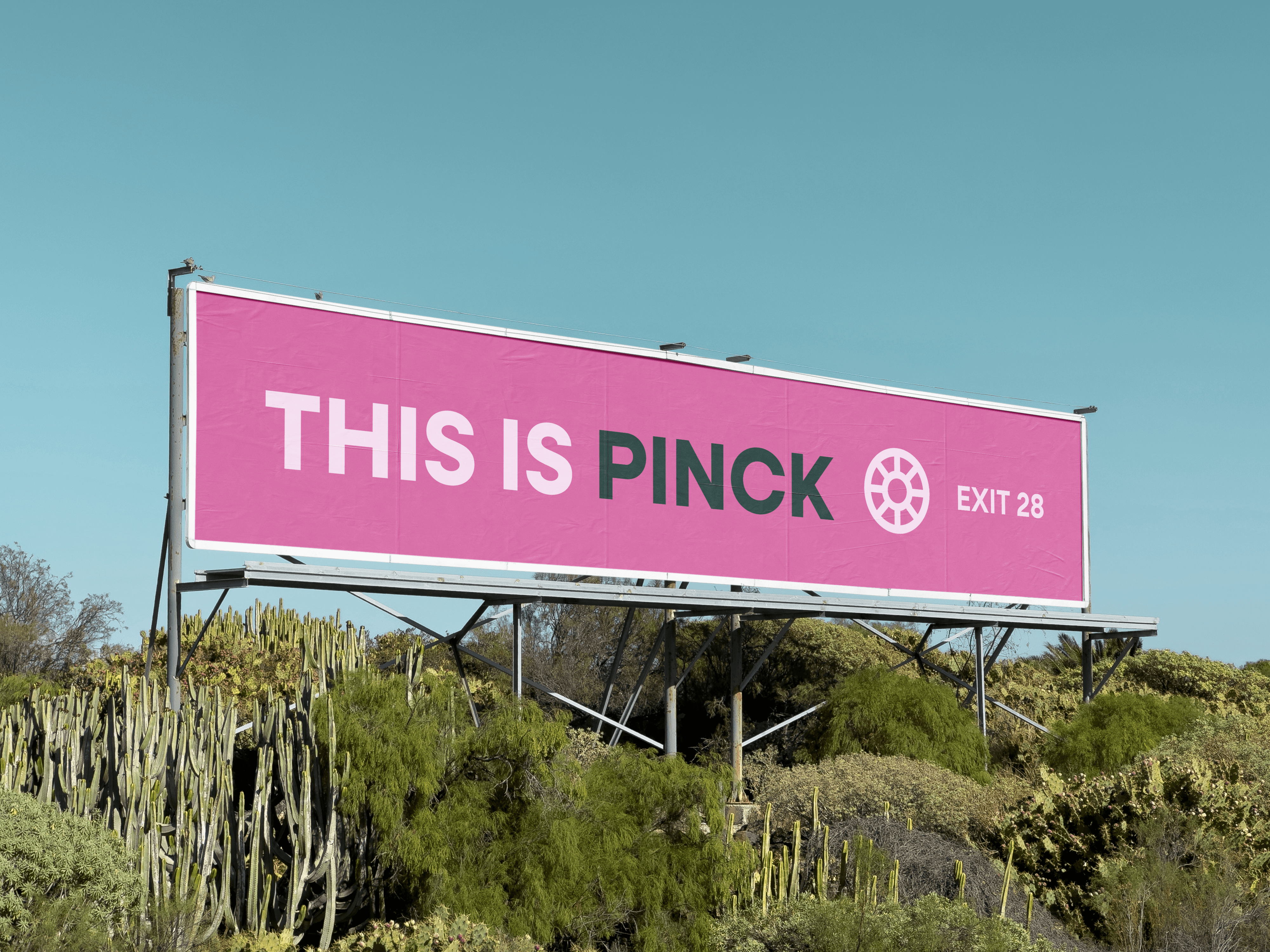 A black and white photo of a person with long hair leaning over a surfboard. The focus is on the arms and hands of the person resting on the board.