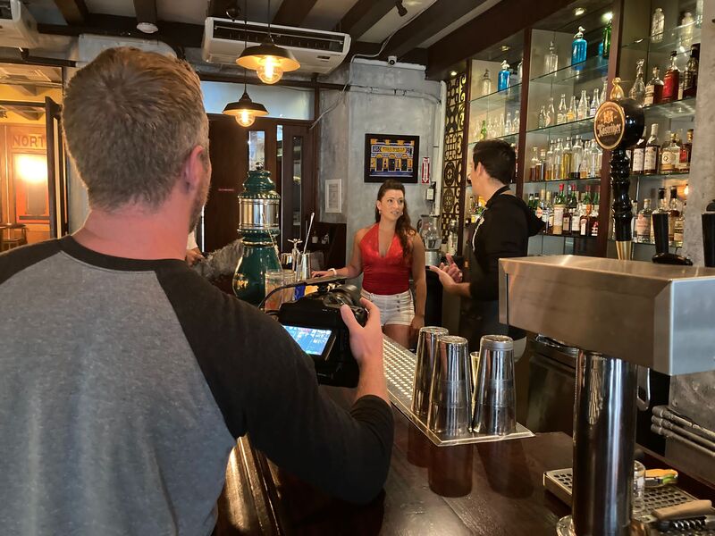 Director filming a woman in red at a bar during production of Puerto Ricans on the Rise, Puerto Rico