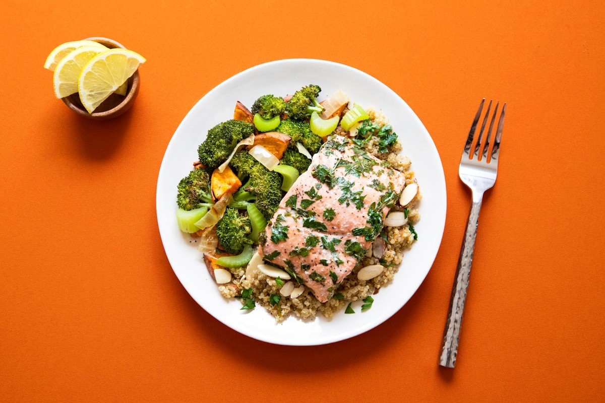 A plate of grilled salmon over quinoa with roasted broccoli, a naturally gluten-free dinner