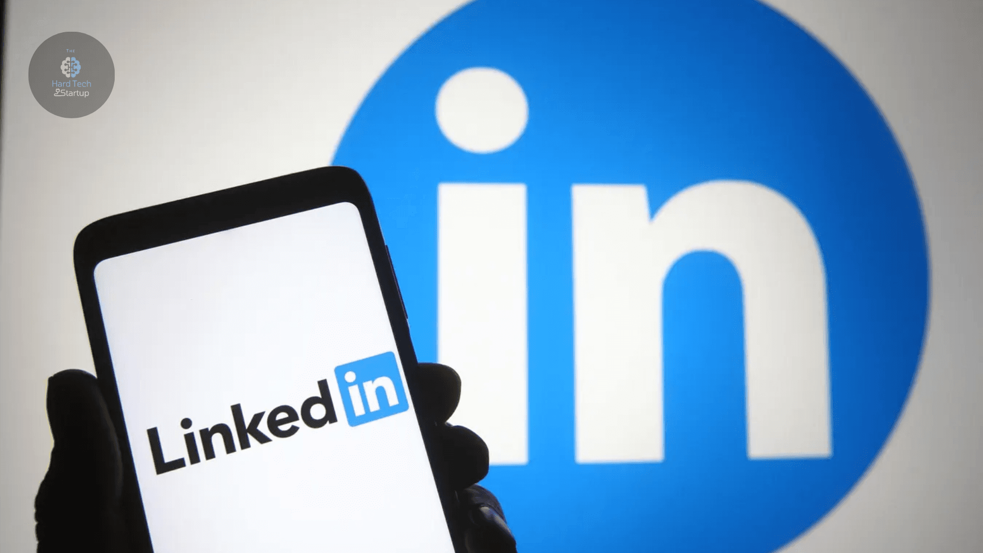LinkedIn app opened on the phone with LinkedIn logo in the background