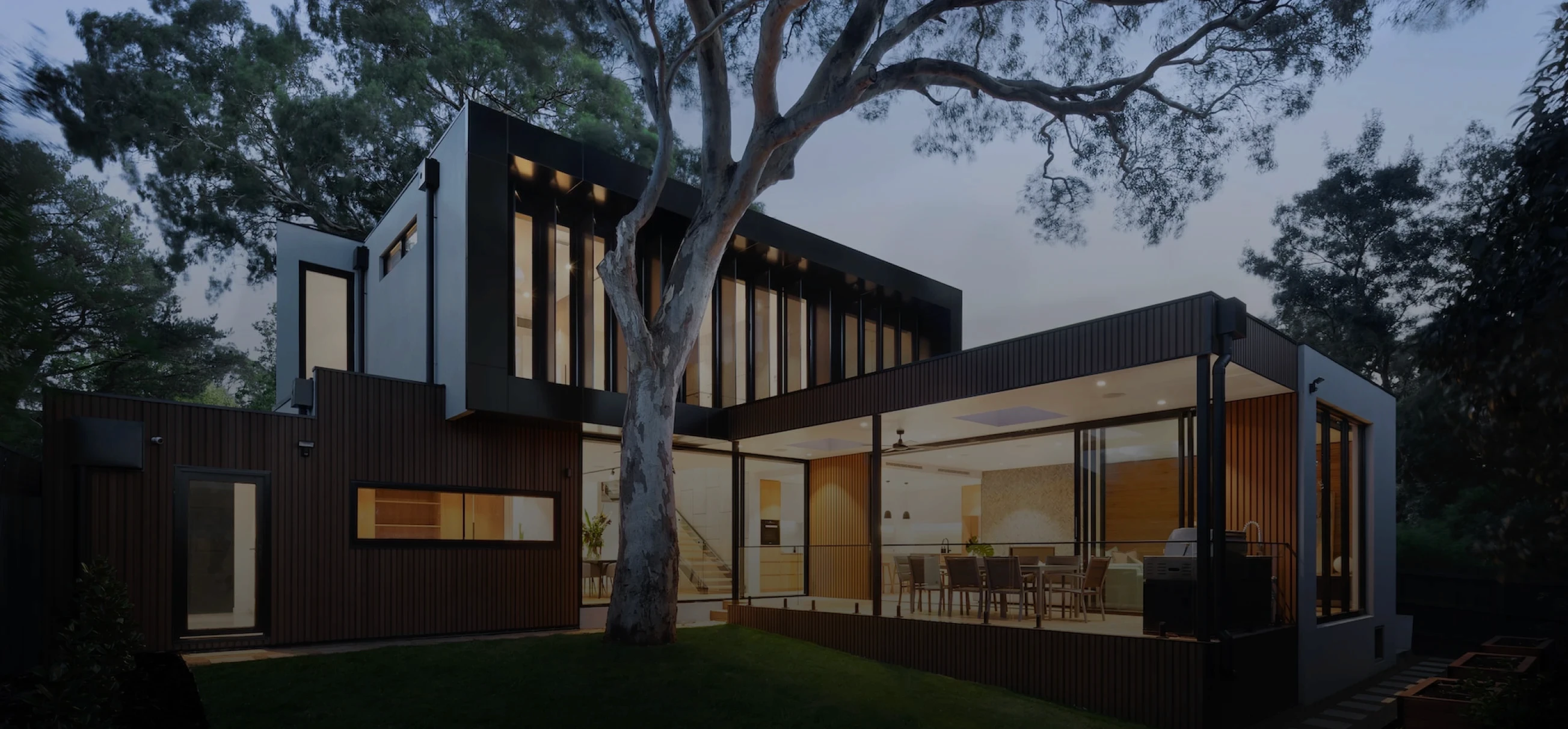 fachada de casa elegante e moderna, repleta de vidros e luzes para ressaltar a imponência da casa.