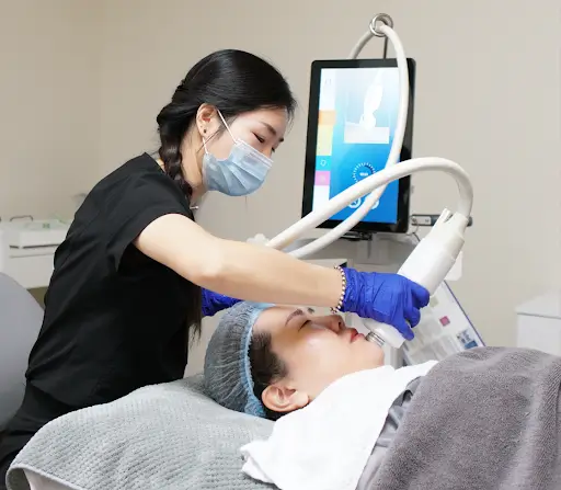 Clinician operating laser skin treatment on a patient.