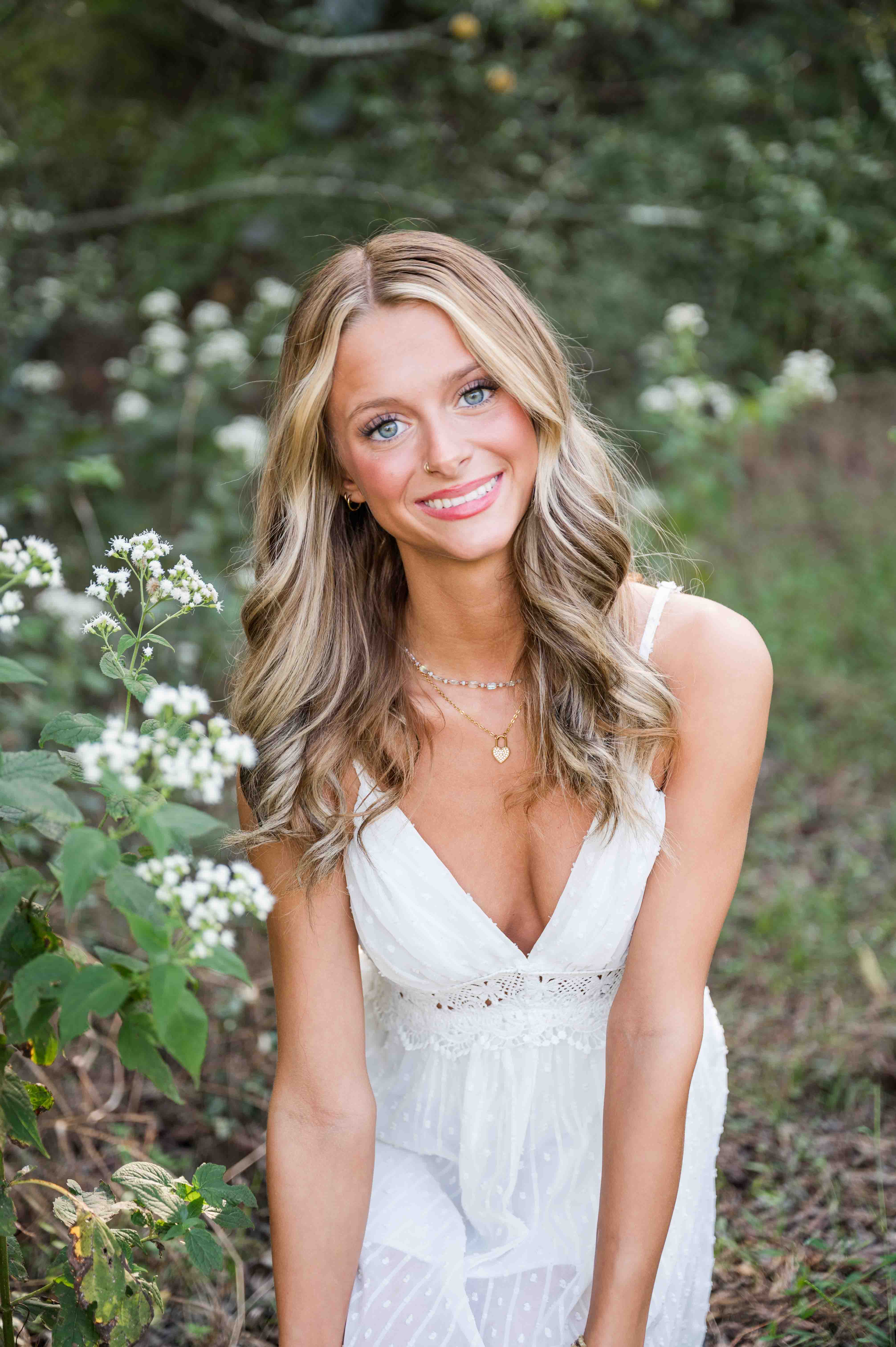 Senior session portrait in park with wild flowers.
