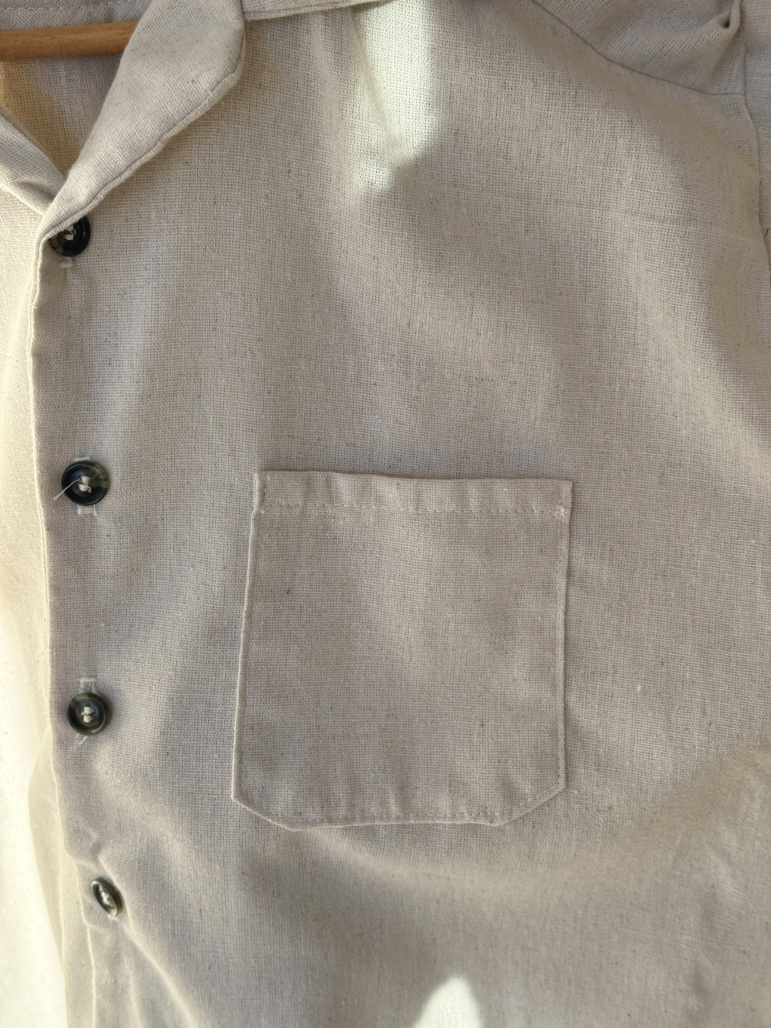Close-up of off-white button down t-shirt chest pocket