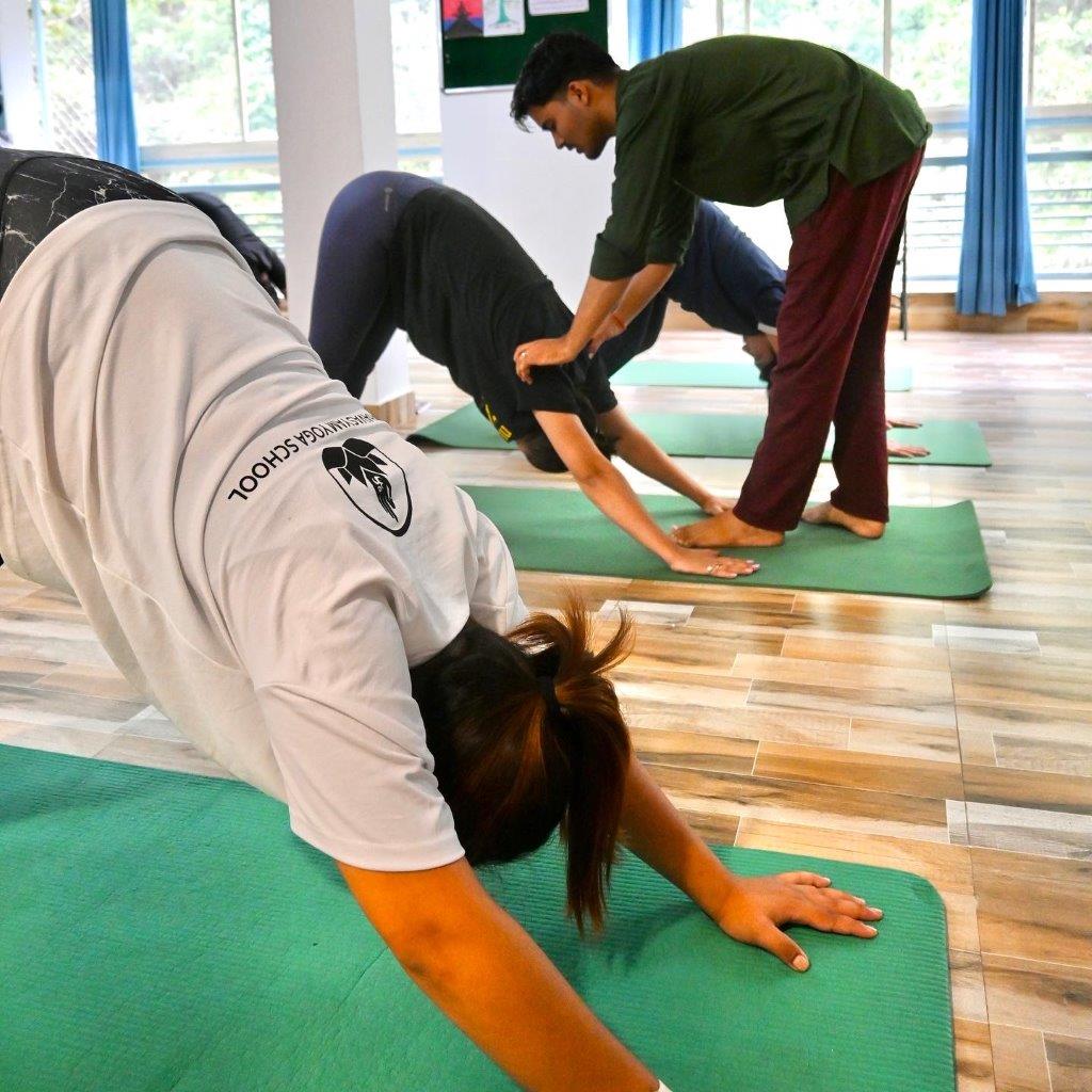 yoga teacher instructing student