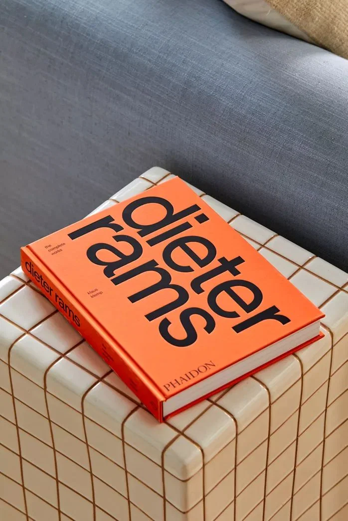 Portada naranja del libro «Dieter Rams», de Phaidon, sobre una superficie alicatada.