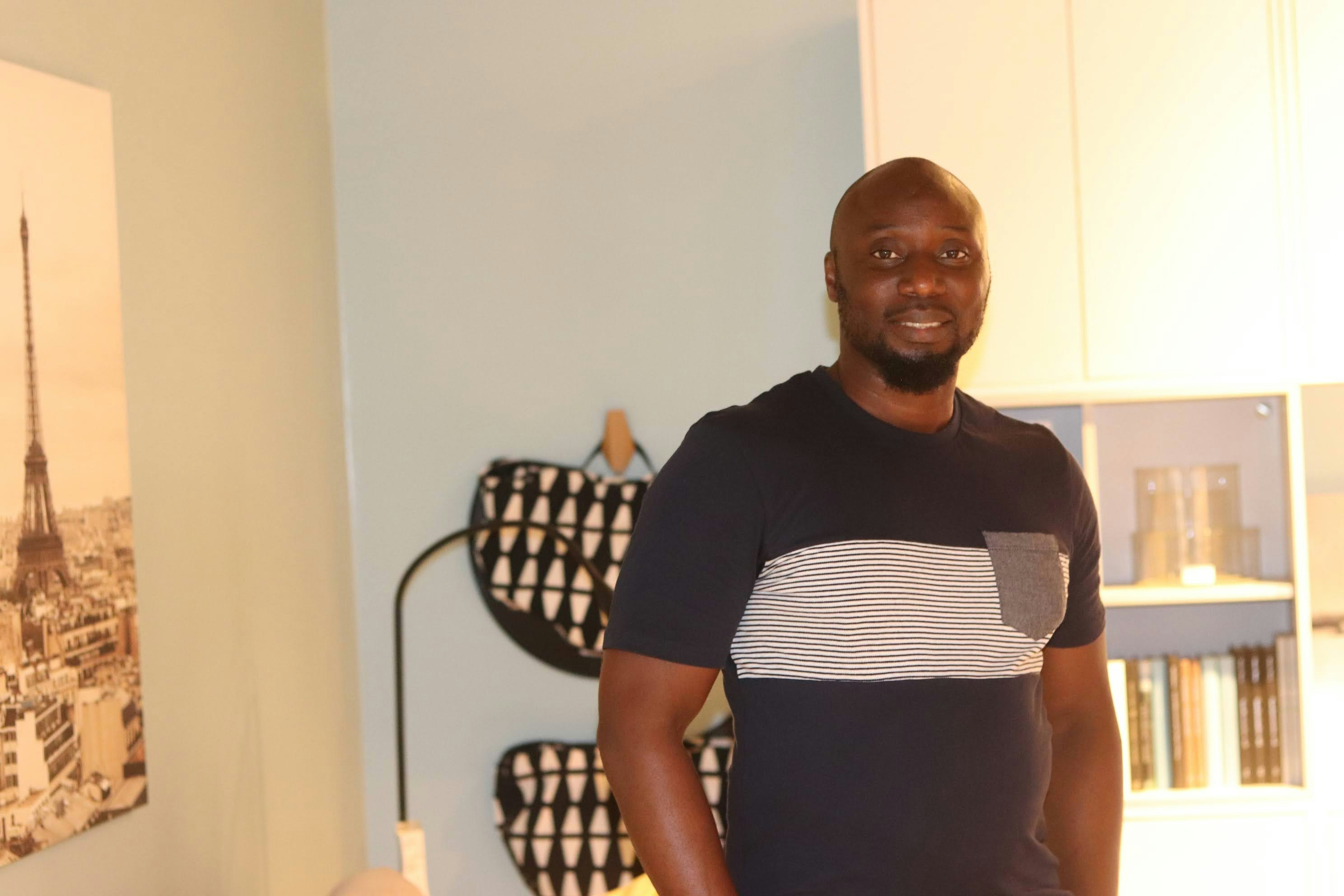 A man standing in a kitchen in front of a painting