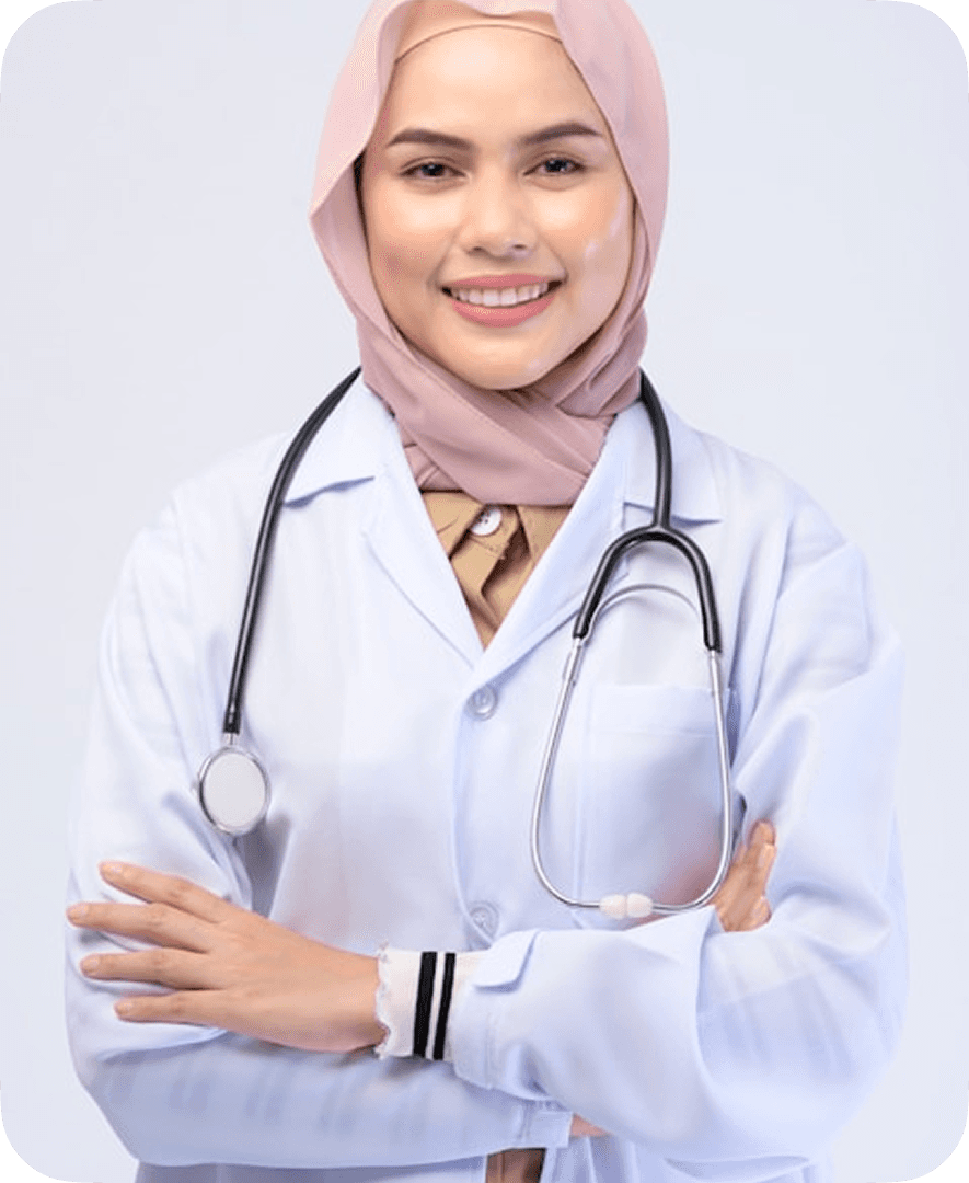 A confident healthcare professional wearing a stethoscope and a light pink hijab smiles while dressed in a white medical coat against a plain background.