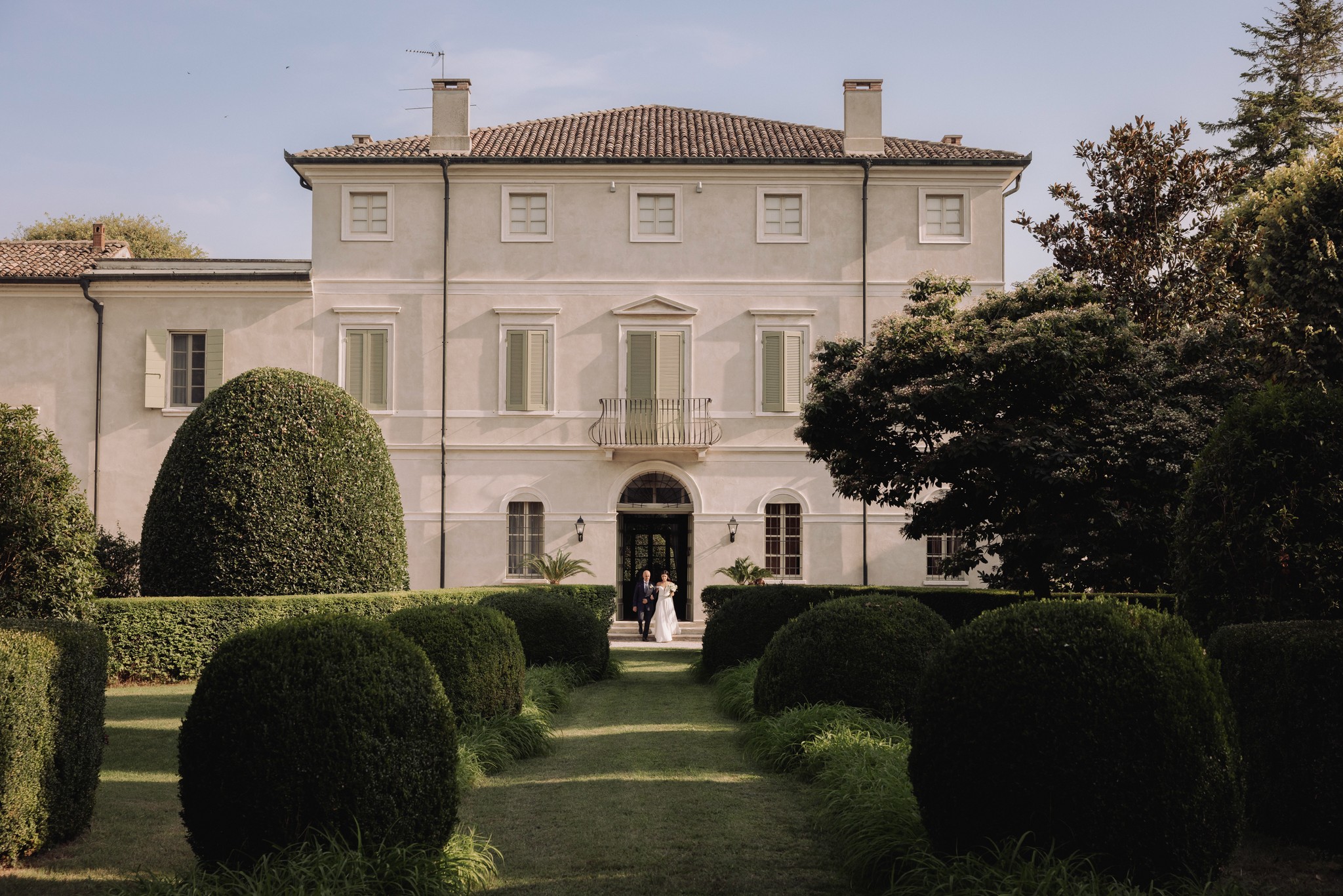 Sposi tra le siepi potate del giardino di Villa Negri, approccio alla villa durante il reportage di matrimonio