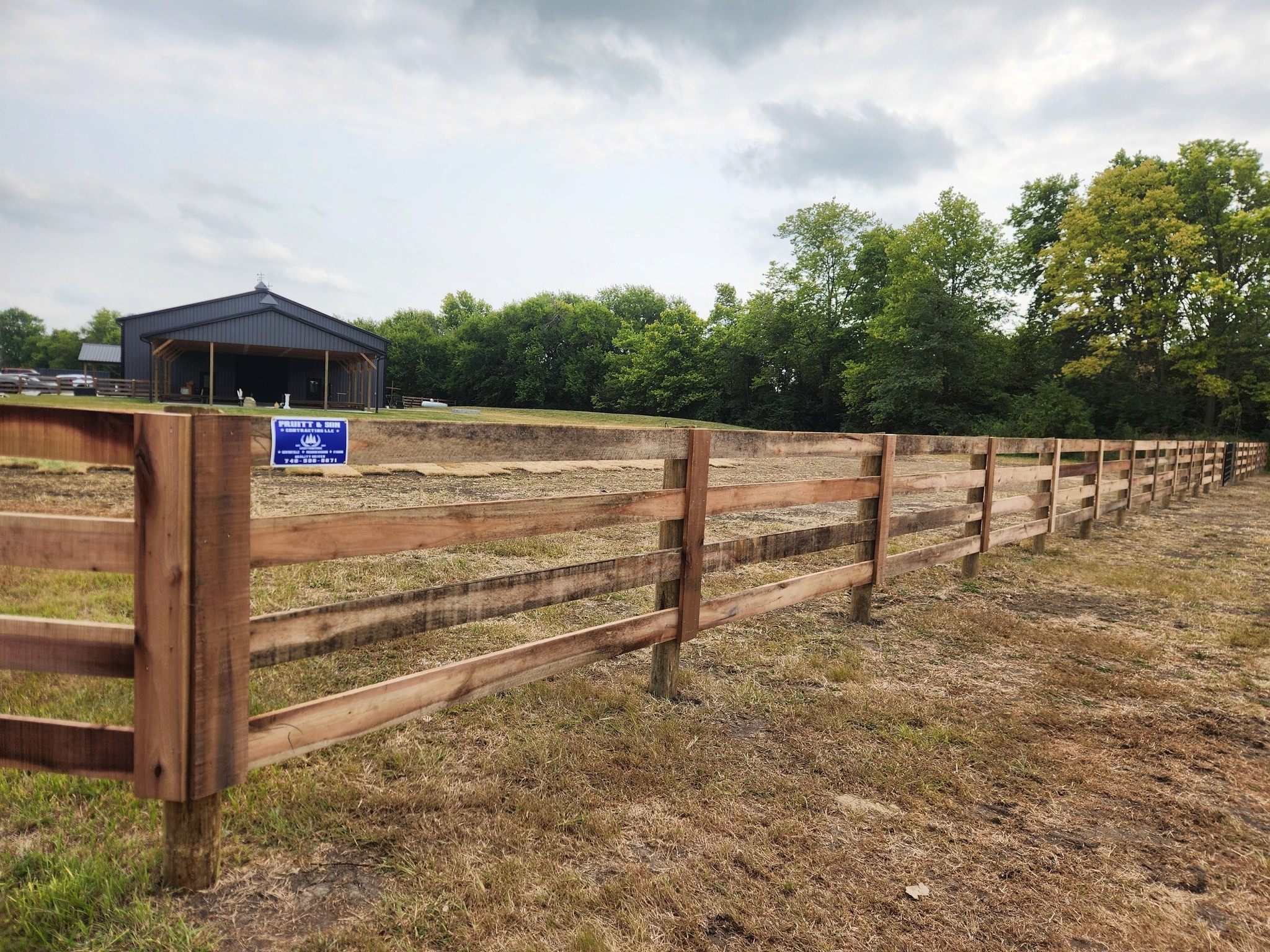 Modern living room with abstract art, beige sectional sofa, indoor plants, and large windows.