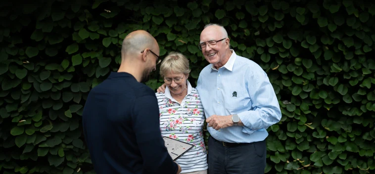 Energieberater Salihu im Beratungsgespräch zur energetischen Sanierung mit Frau und Herr Stein. In der Hand hält er ein Tablet mit der viadukt plattform die ihn bei der Beratung unterstützt