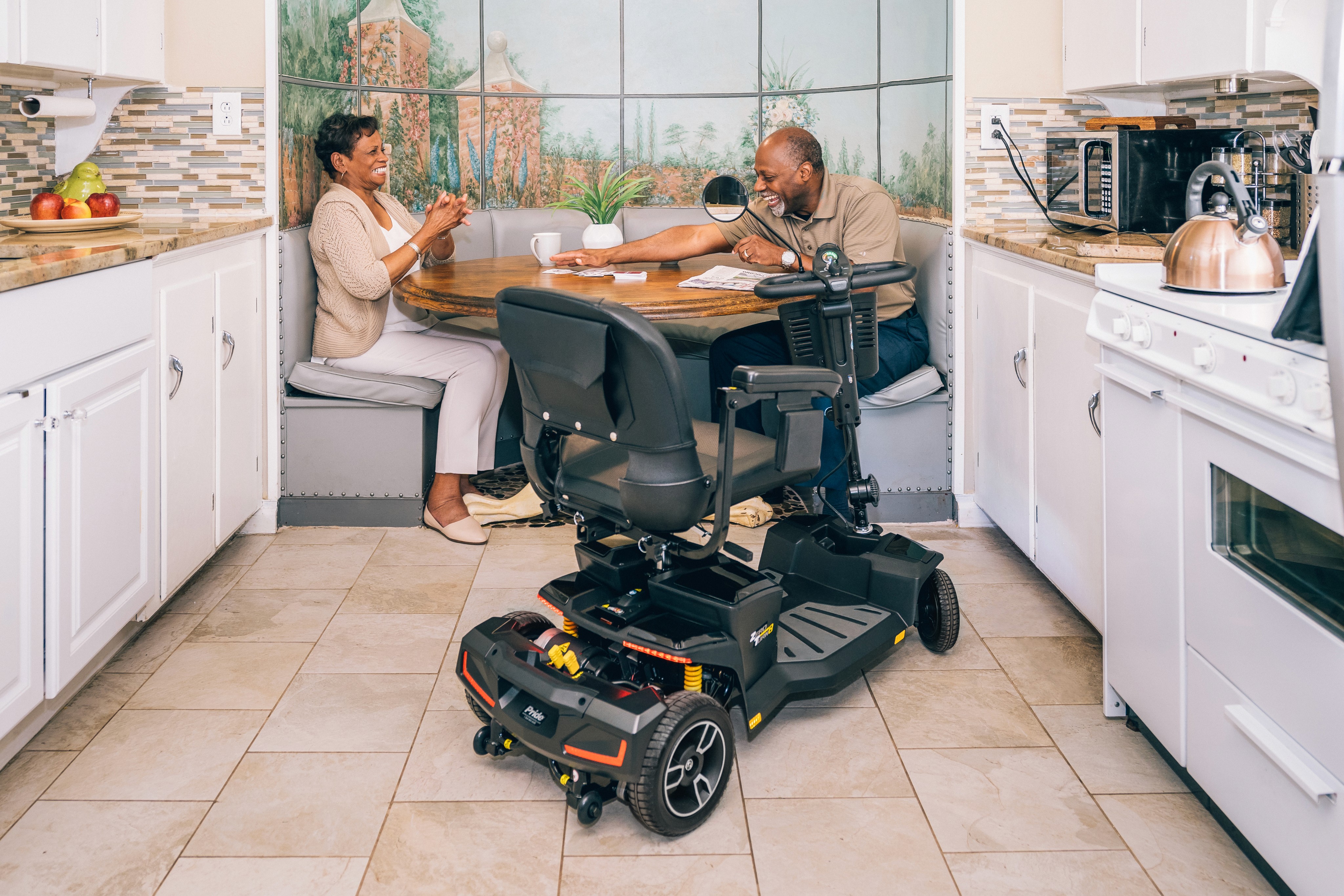 A couple having a discussion over the kitchen table, with a parked scooter nearby