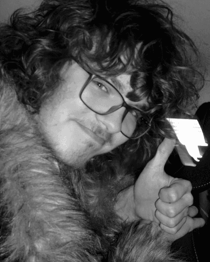 Salvijus Striungys holding a thumbs up at the camera, wearing a furry coat.
