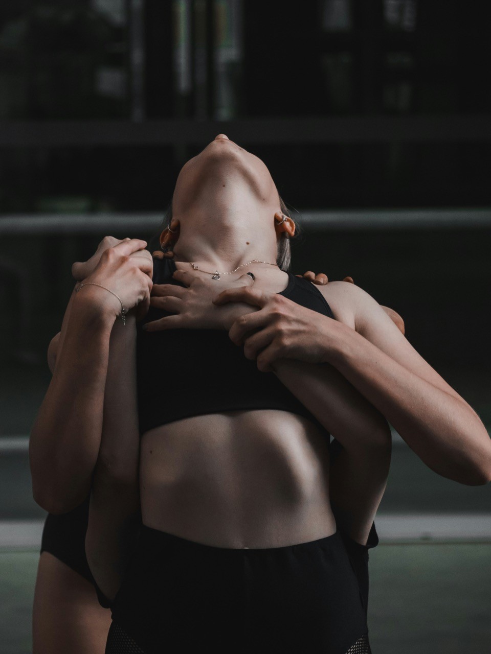a woman in a black sports bra is holding another woman in a black sports bra