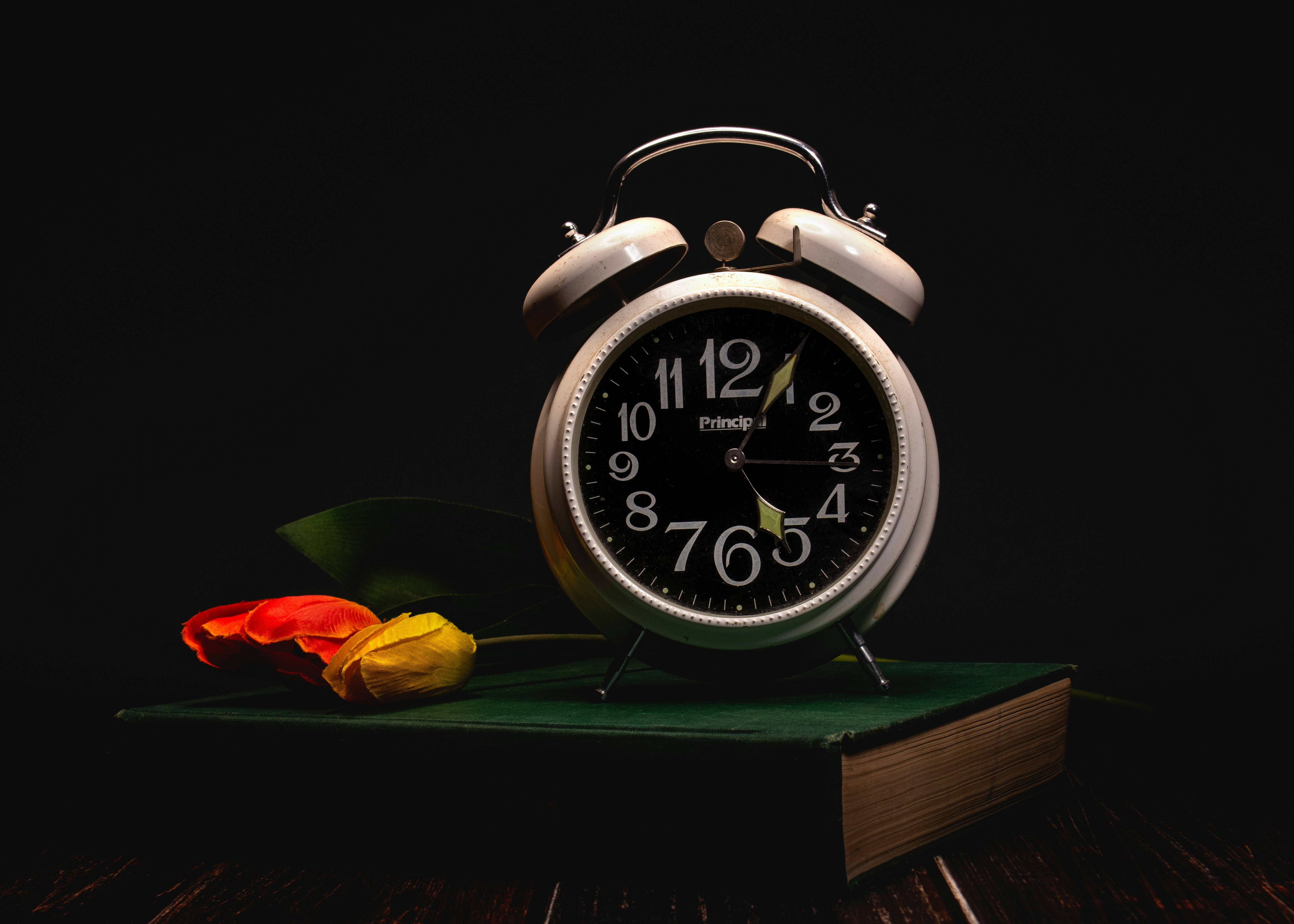 Alarm clock with flowers on a book