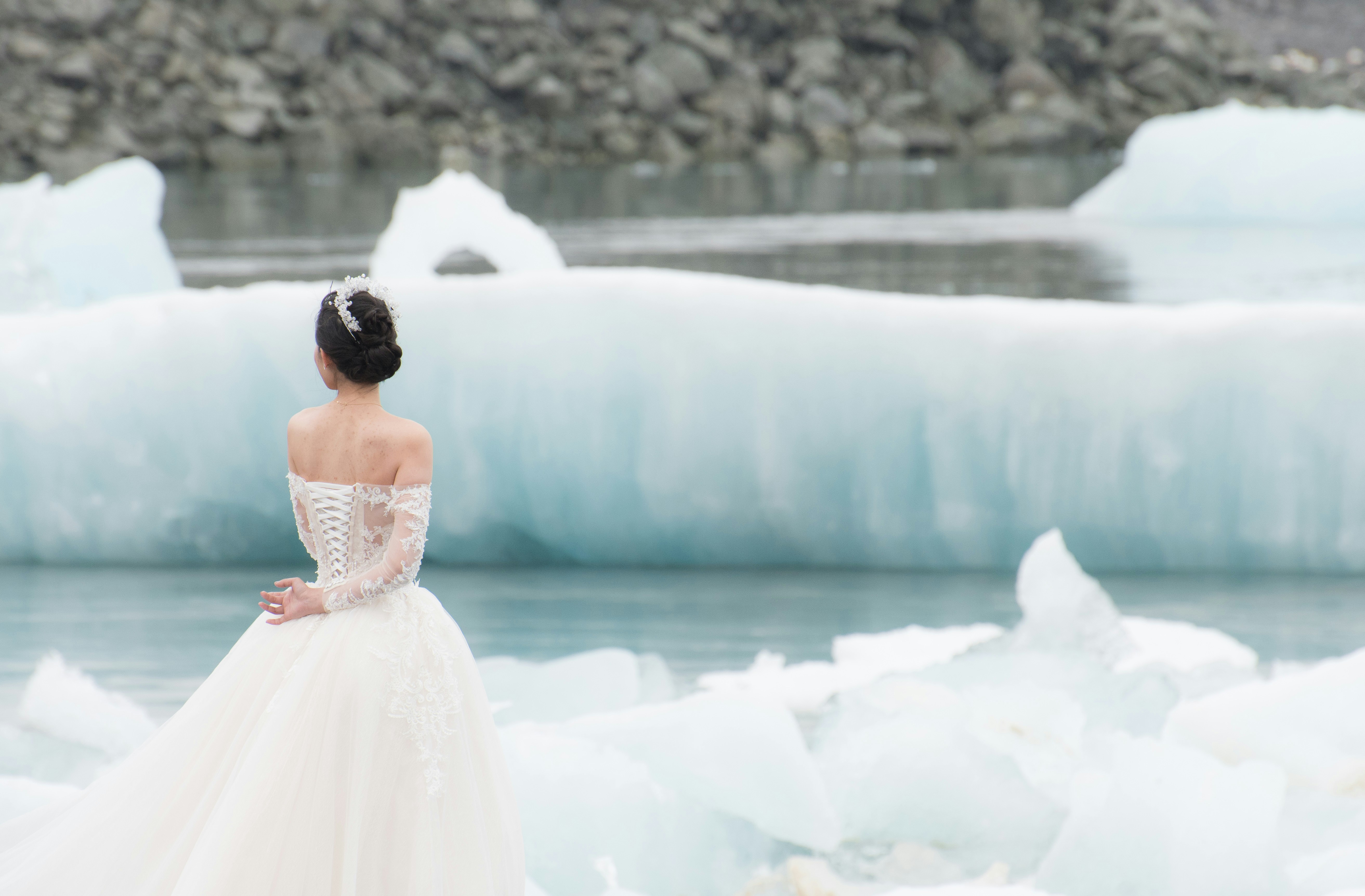 A bride posing in front of a floating glacier in Iceland.