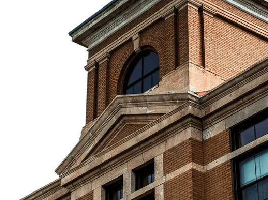 Historic brick building facade with arched windows and detailed architecture.