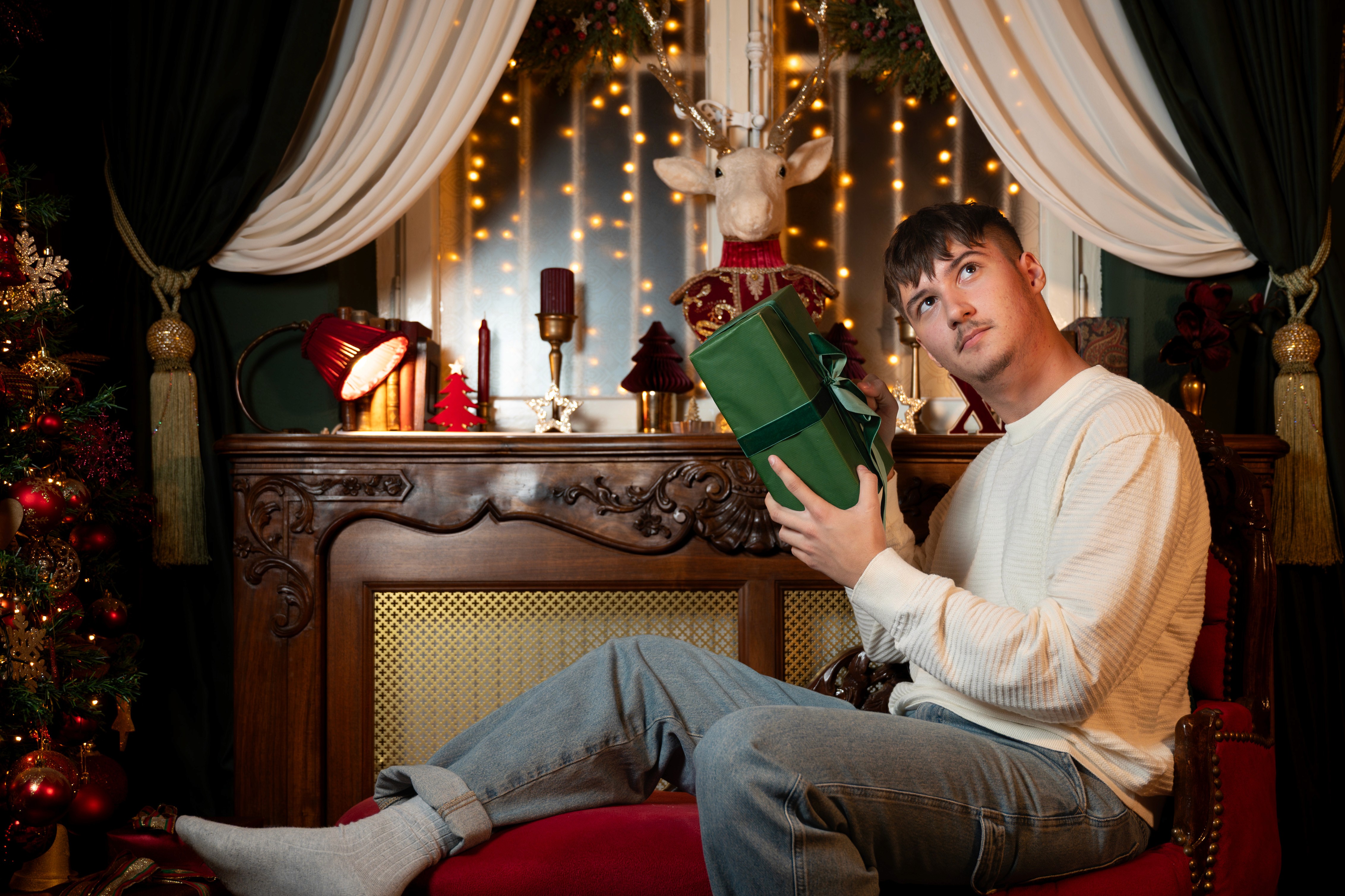 Ședință foto de Crăciun cu bărbat și carte, decor elegant și lumină ambientală
