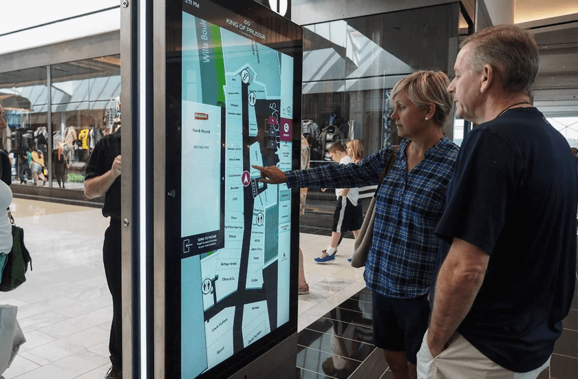 A couple using a touchscreen wayfinder