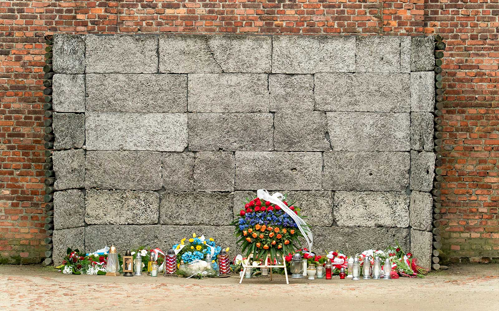 Mindevæg med blomster og lys ved Auschwitz koncentrationslejr.