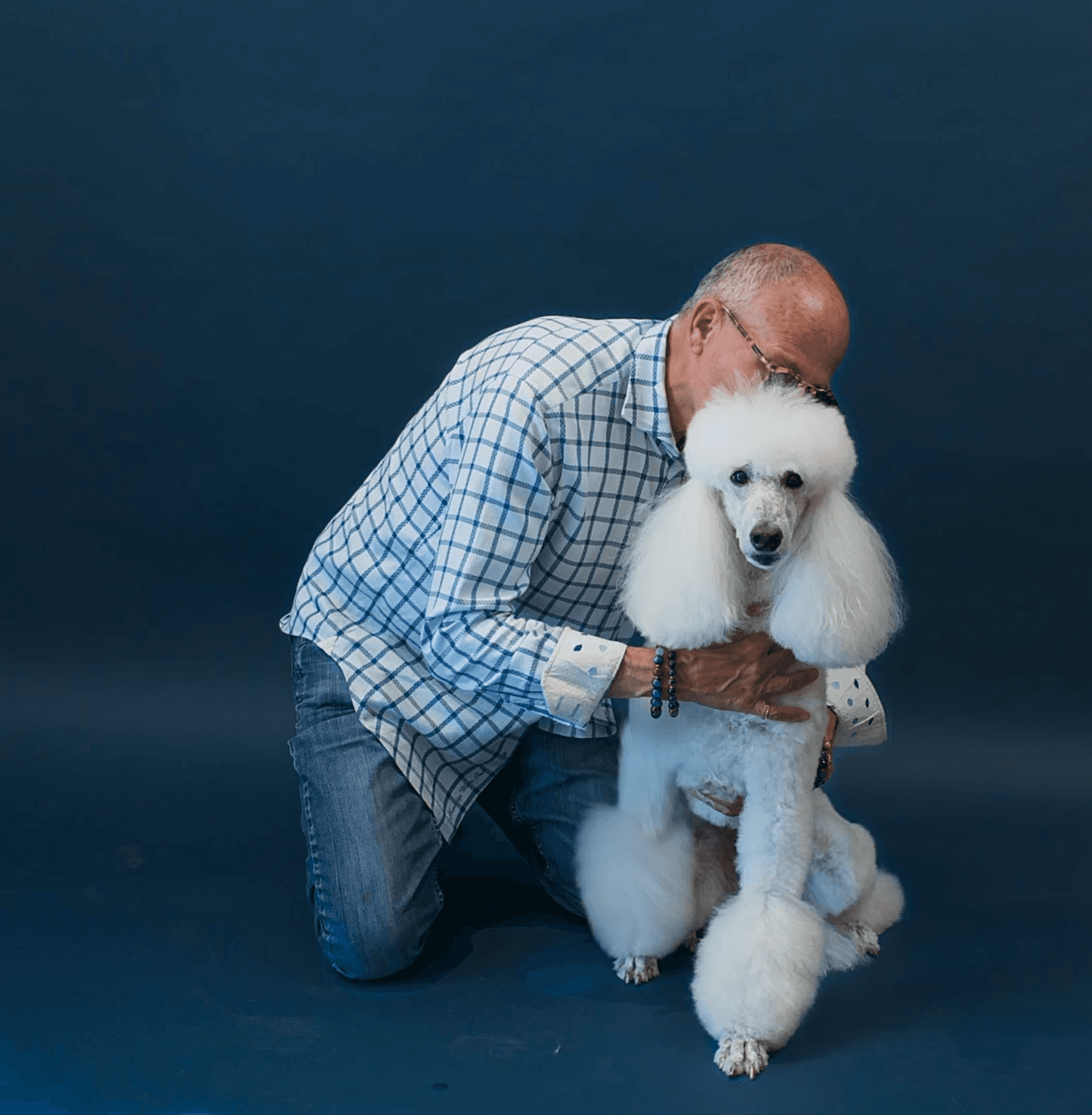 Older man embracing his white dog with a smile to capture trust, companionship, and long-term client care.