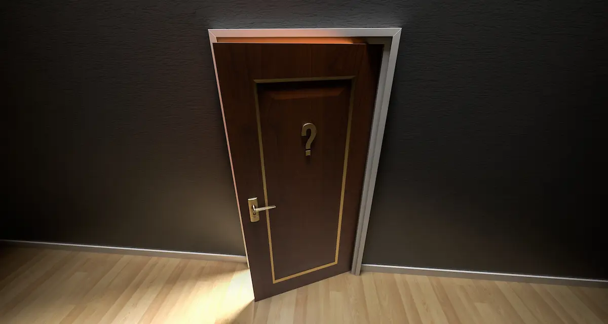 A wooden door left slightly ajar, light spilling through the gap