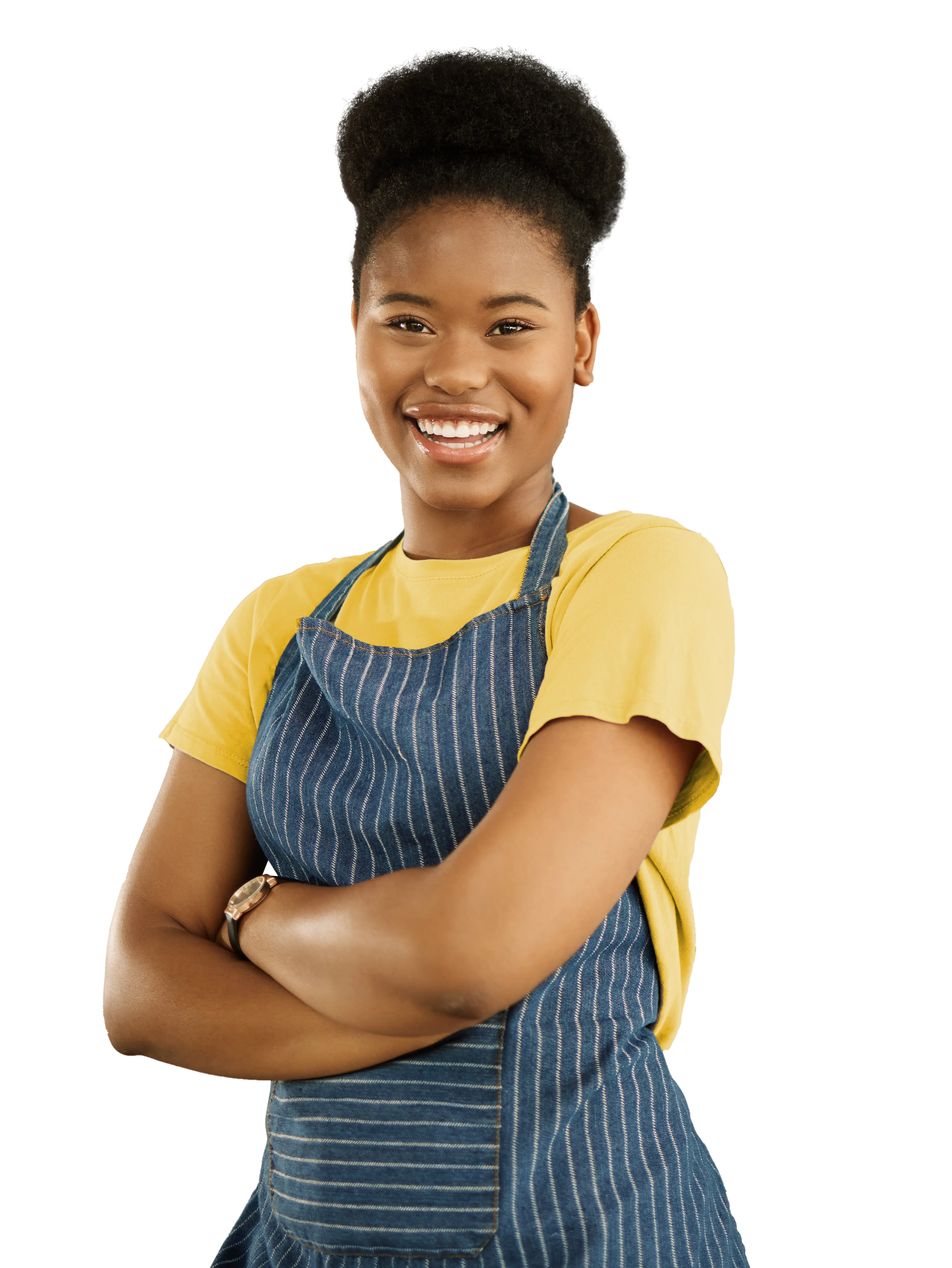 A smiling young woman in a yellow shirt and denim overalls stands confidently with crossed arms.