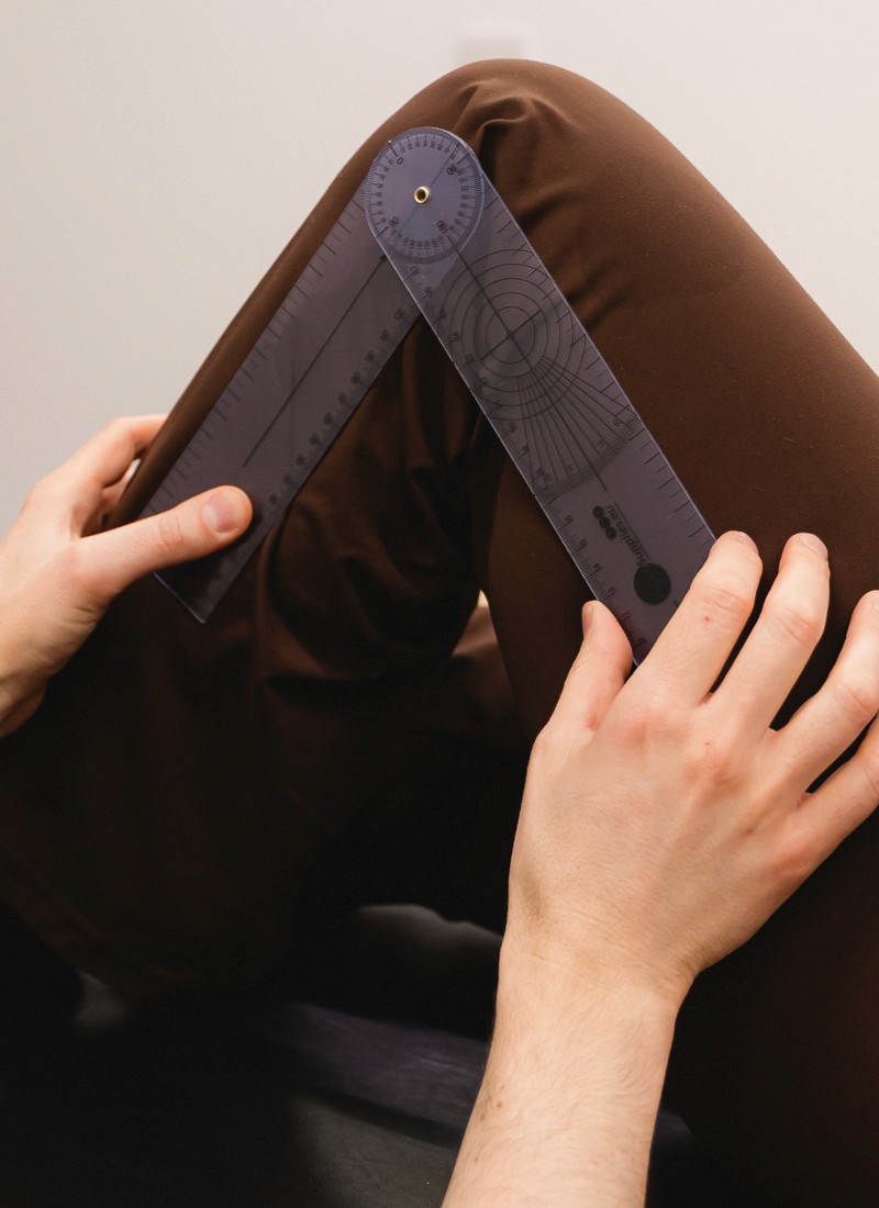 Closeup of a physiotherapist measuring the angle of a knee bend