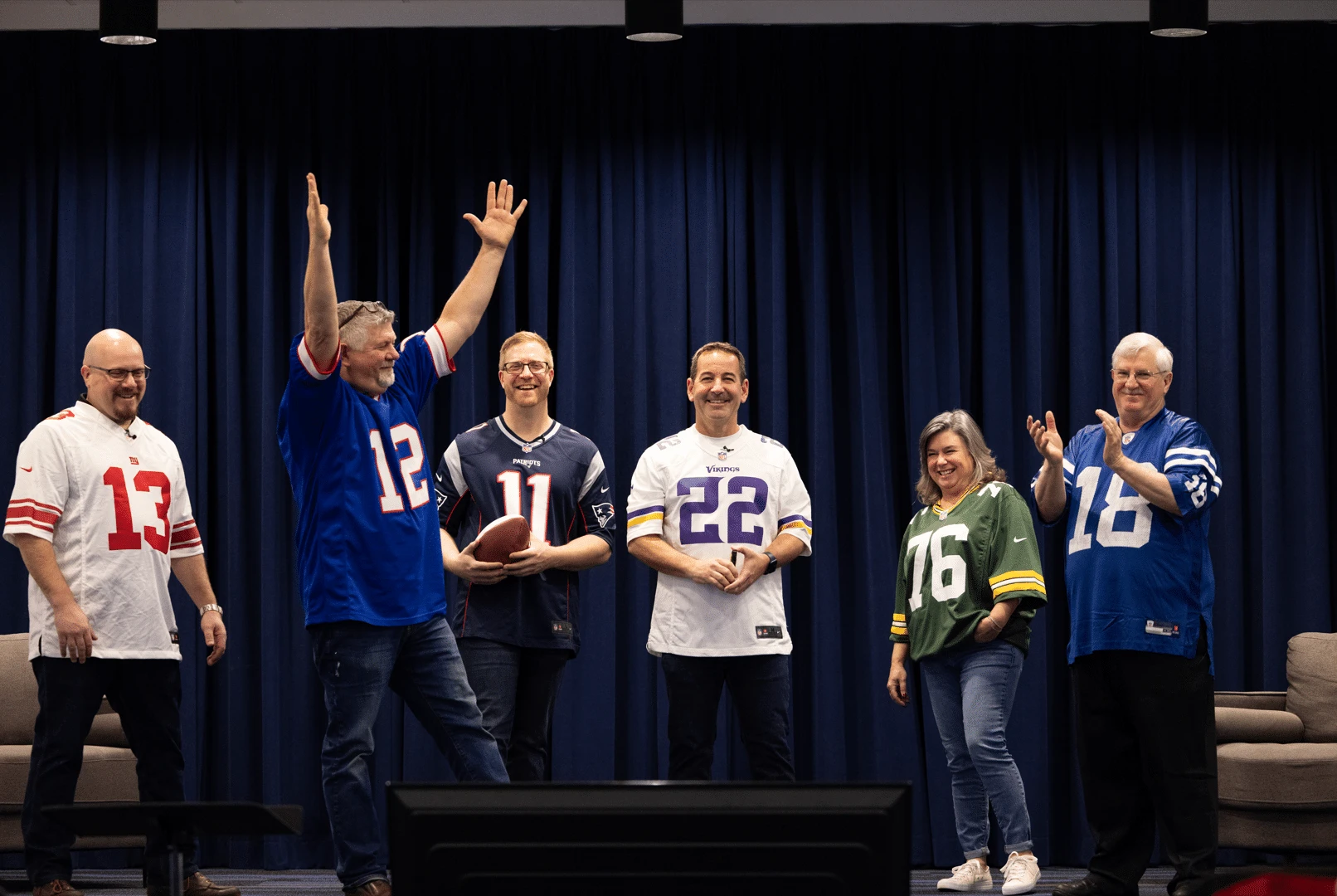 Office leadership team wearing football jerseys at the company from headquarters