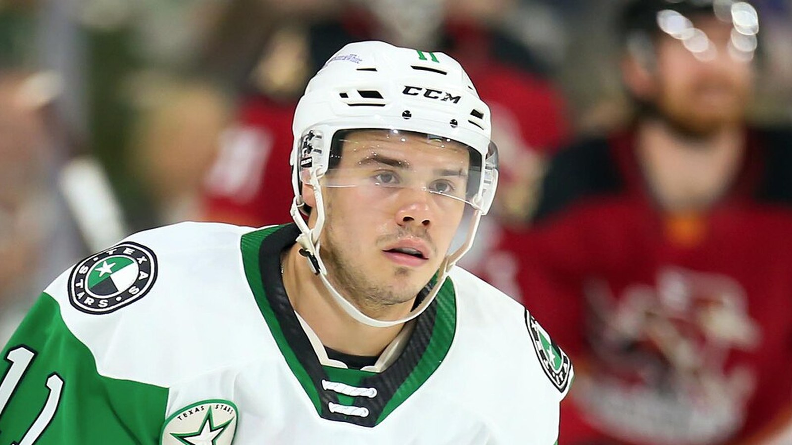 Logan Stankoven in a white helmet and green and white Texas Stars jersey, face centered