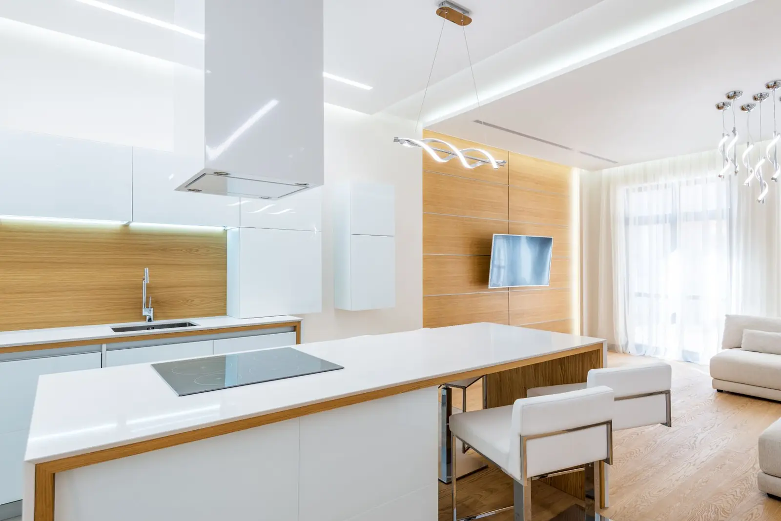 A finished kitchen with white cabinets and stone worktops