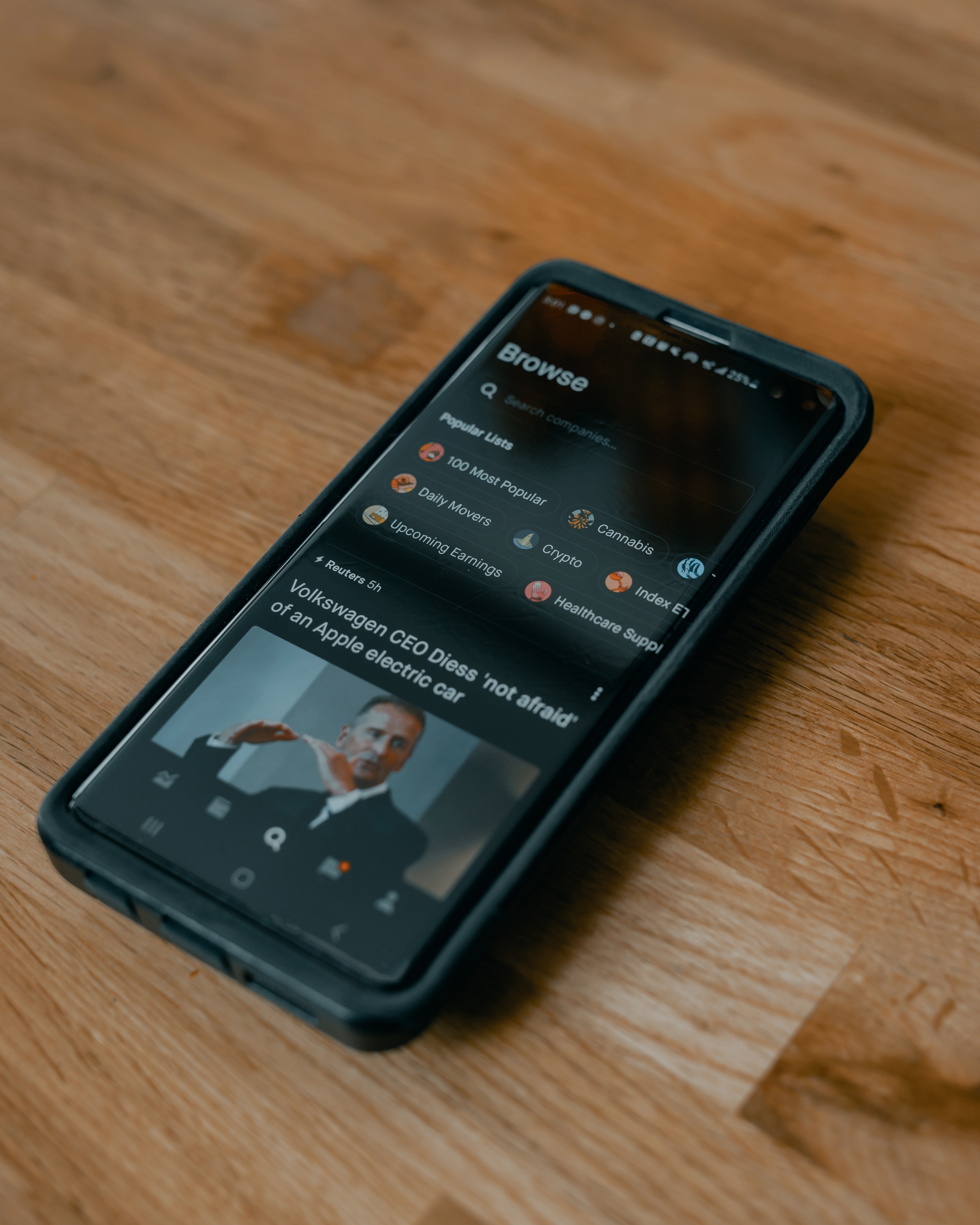 a news app with black background on a wooden table