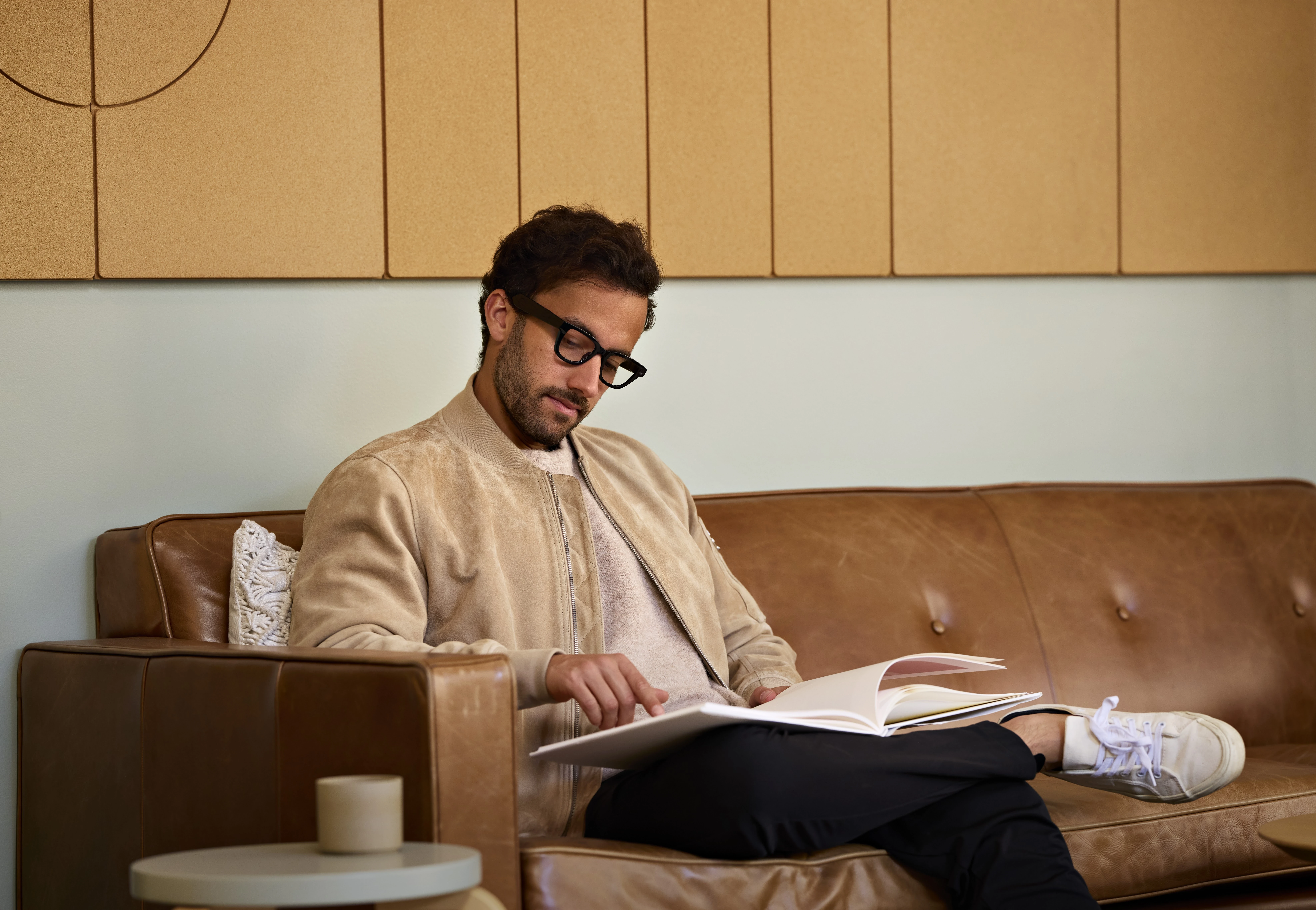 A person wearing Android XR prototype glasses while reading a book on a sofa, shown in Google’s 2025 developer update.