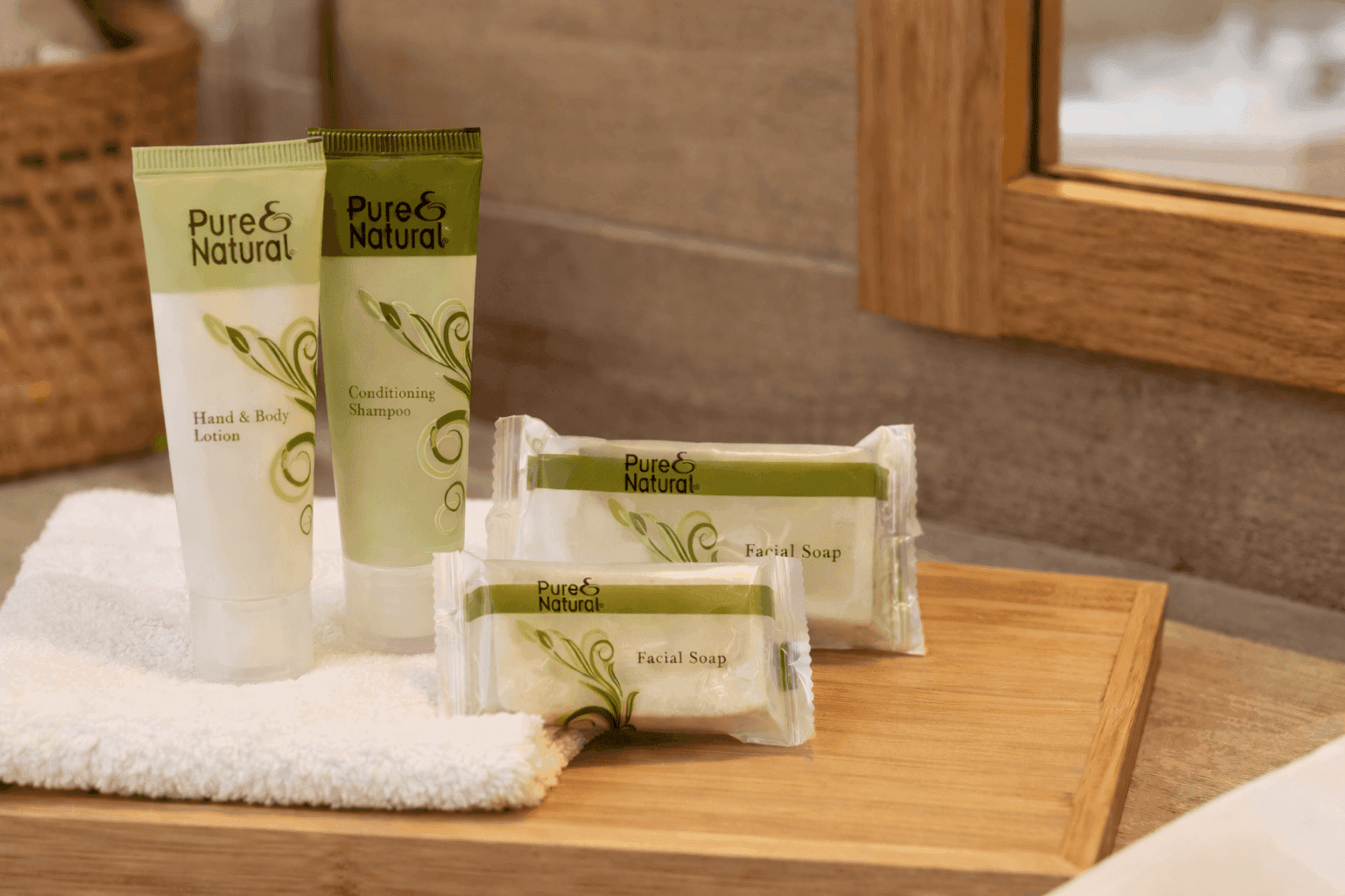 Restore Daily Care Spa hotel amenities collection with aloe-inspired setting, featuring shampoo, conditioner, body wash, lotion, and a smaller wrapped body bar on a stone tray in a relaxing spa environment