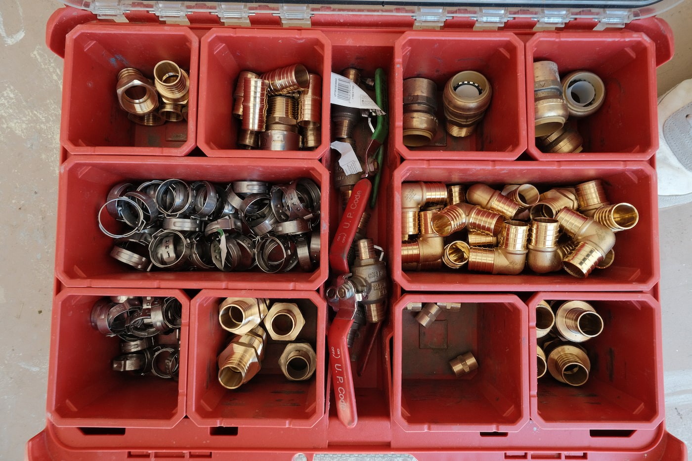 Brass PEX fittings, pipe clamps, and plumbing connectors used by Flowcore Water Services for well water system installations across DFW and North Texas