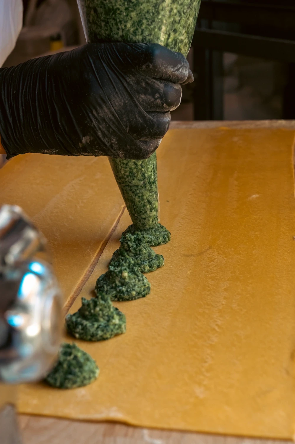 Persona che sta facendo i ravioli ricotta e spinaci Tucci