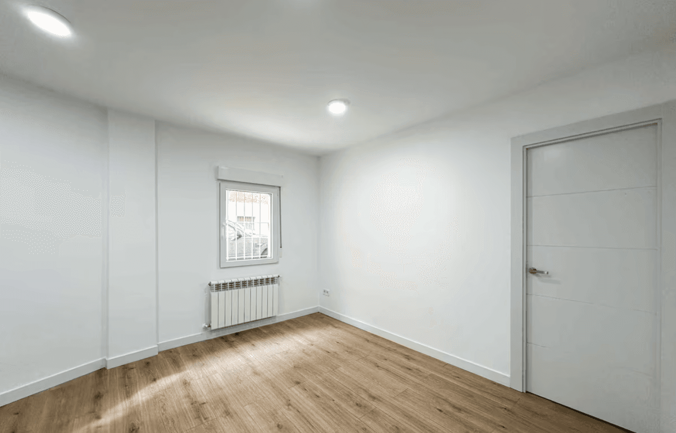 A modern brick house with a two-car garage, well-manicured lawn, and clear blue sky in the background.