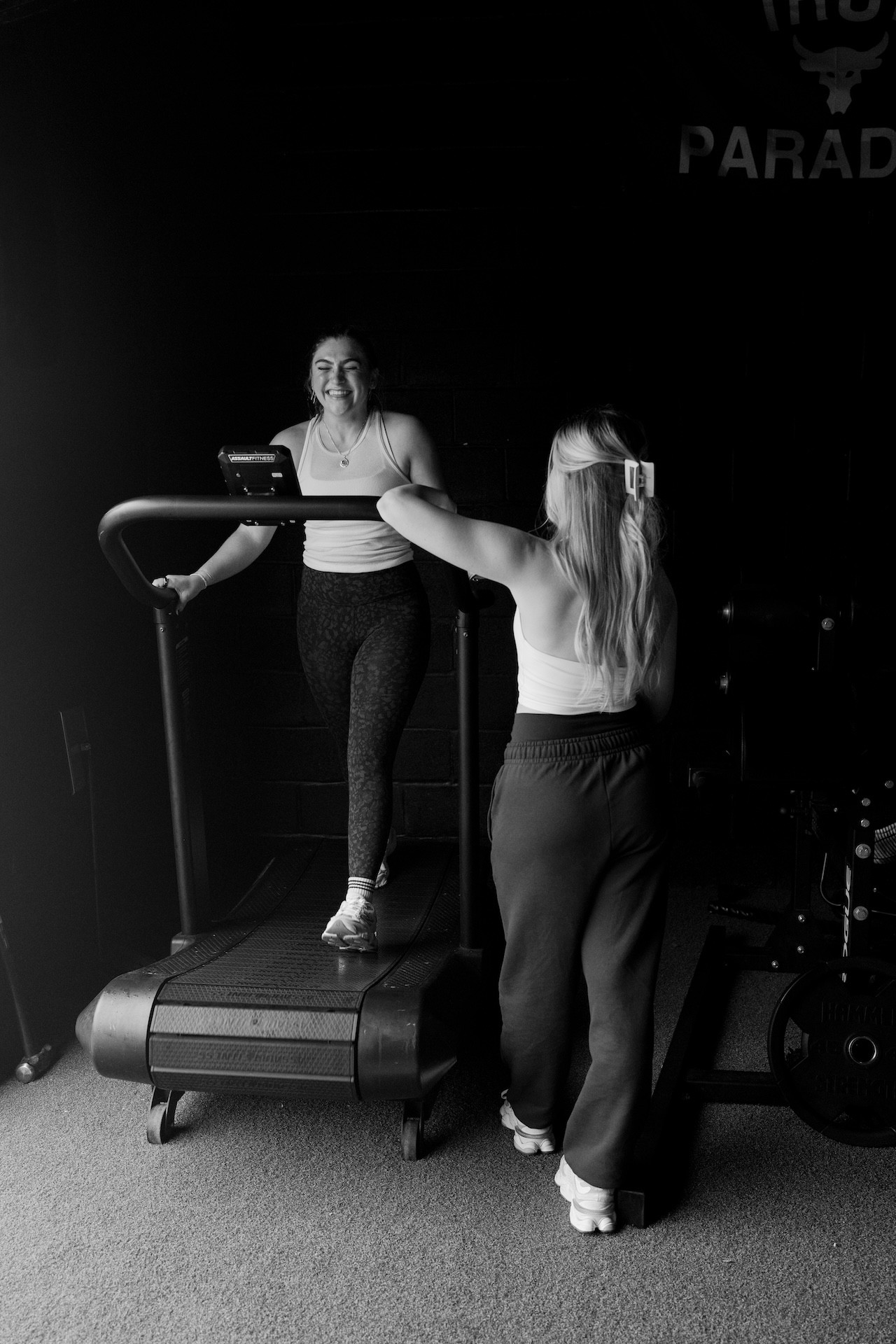 Two women chatting and laughing at a treadmill
