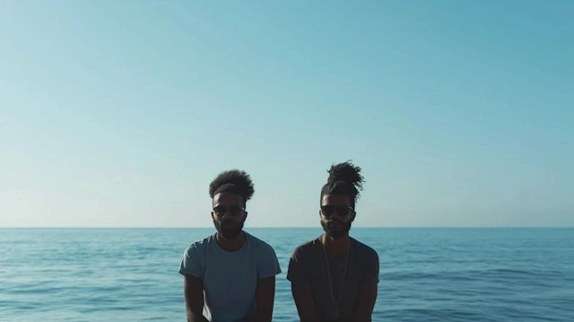 portrait of two young black men at the seaside