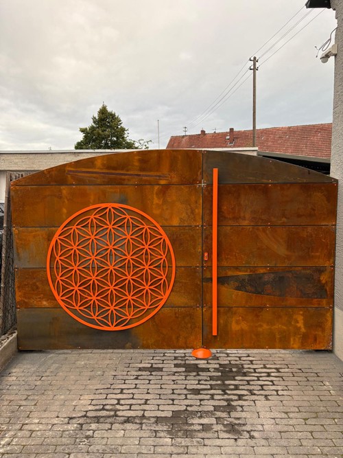 Metalltor mit orangenen Details für eine Einfahrt.