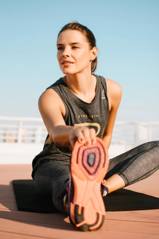 Woman in workout clothing against a clear blue sky
