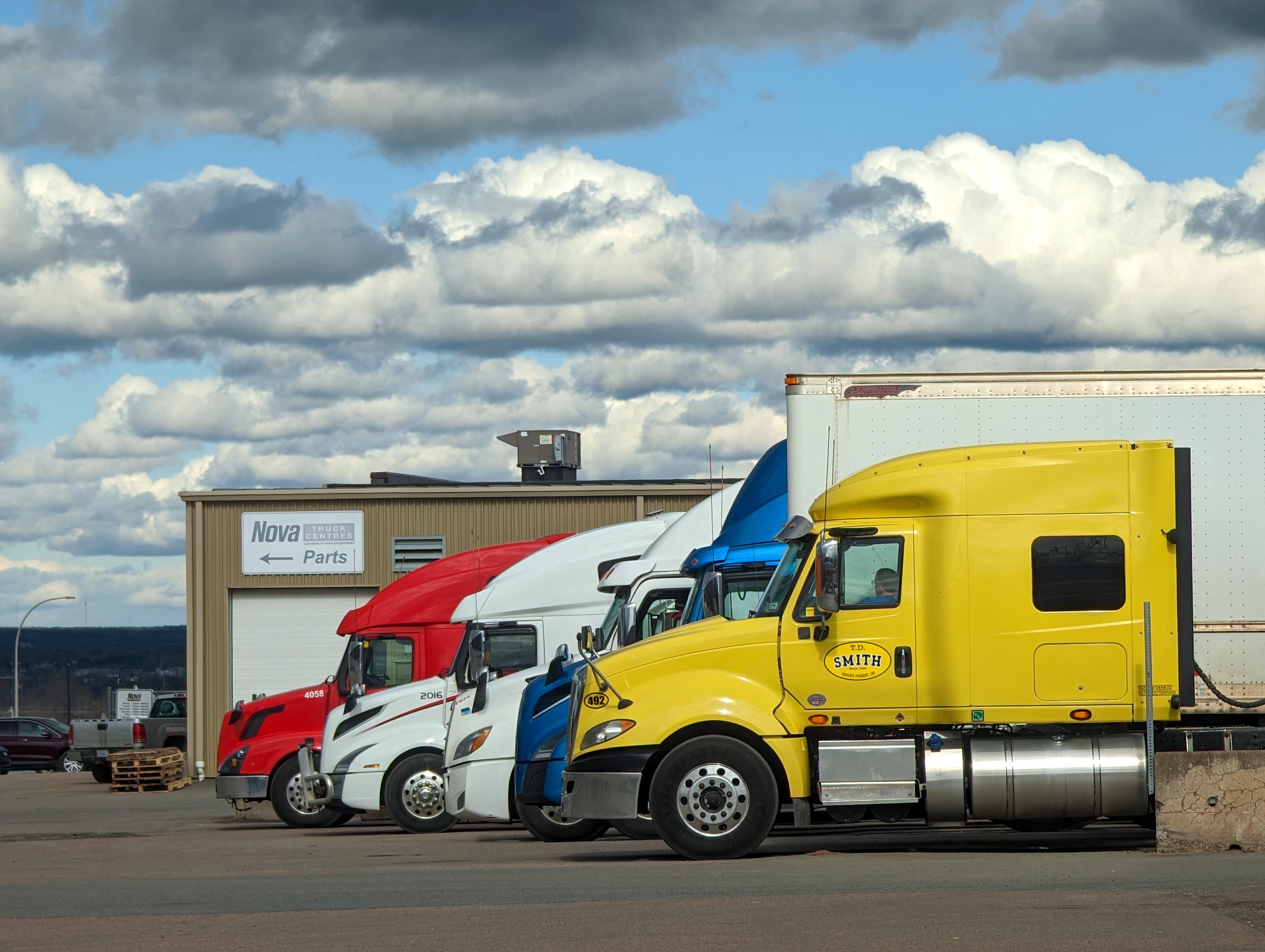 white and blue truck on road during daytime