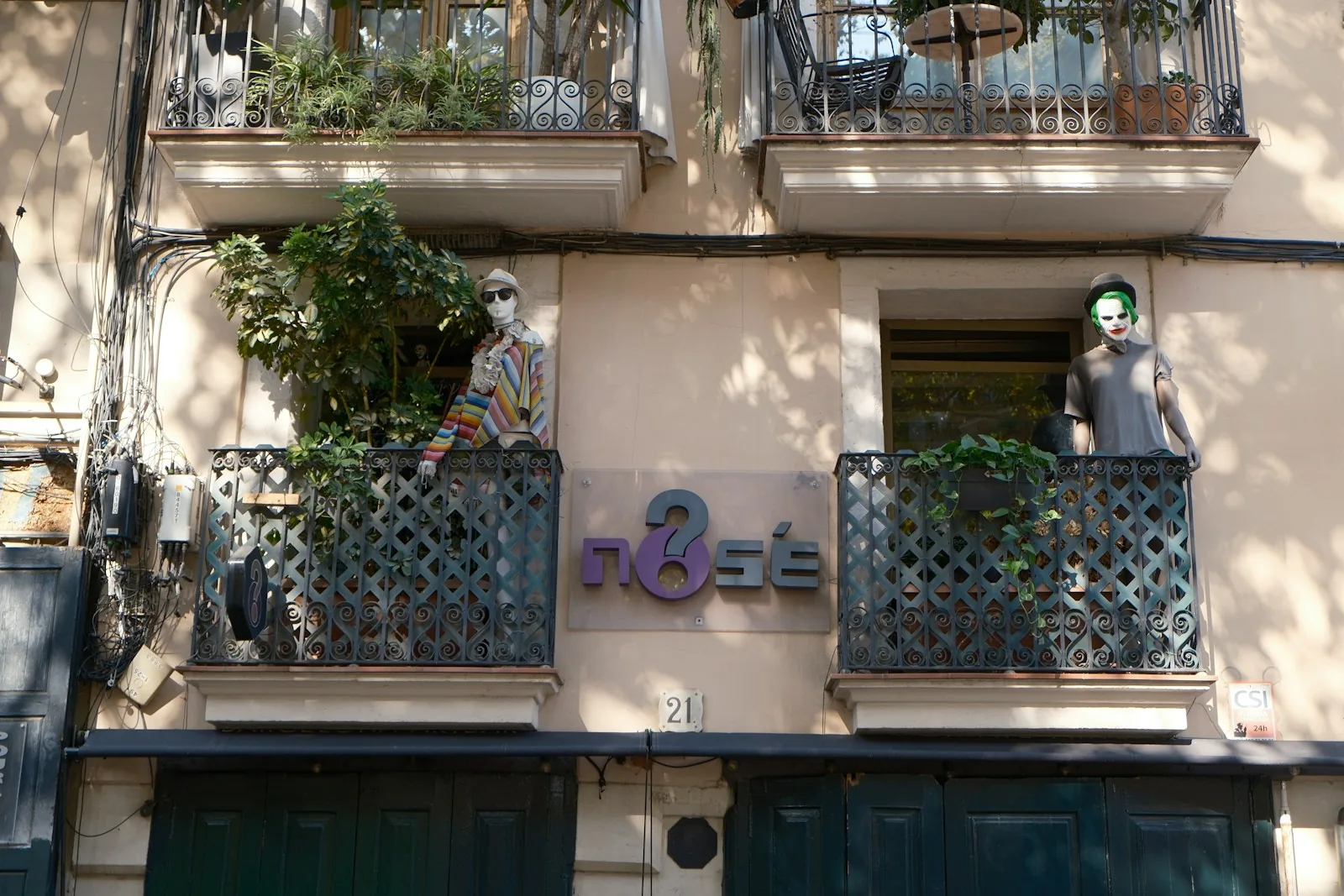 Balconies with plants above a shop front in El Born