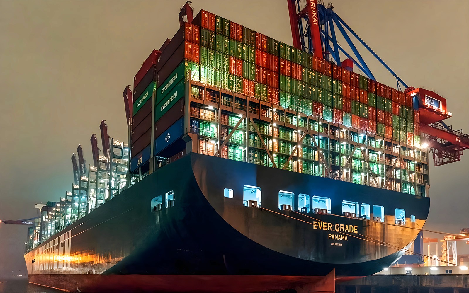 在夜间灯光巡航时，货轮在大港口被灯光照亮。