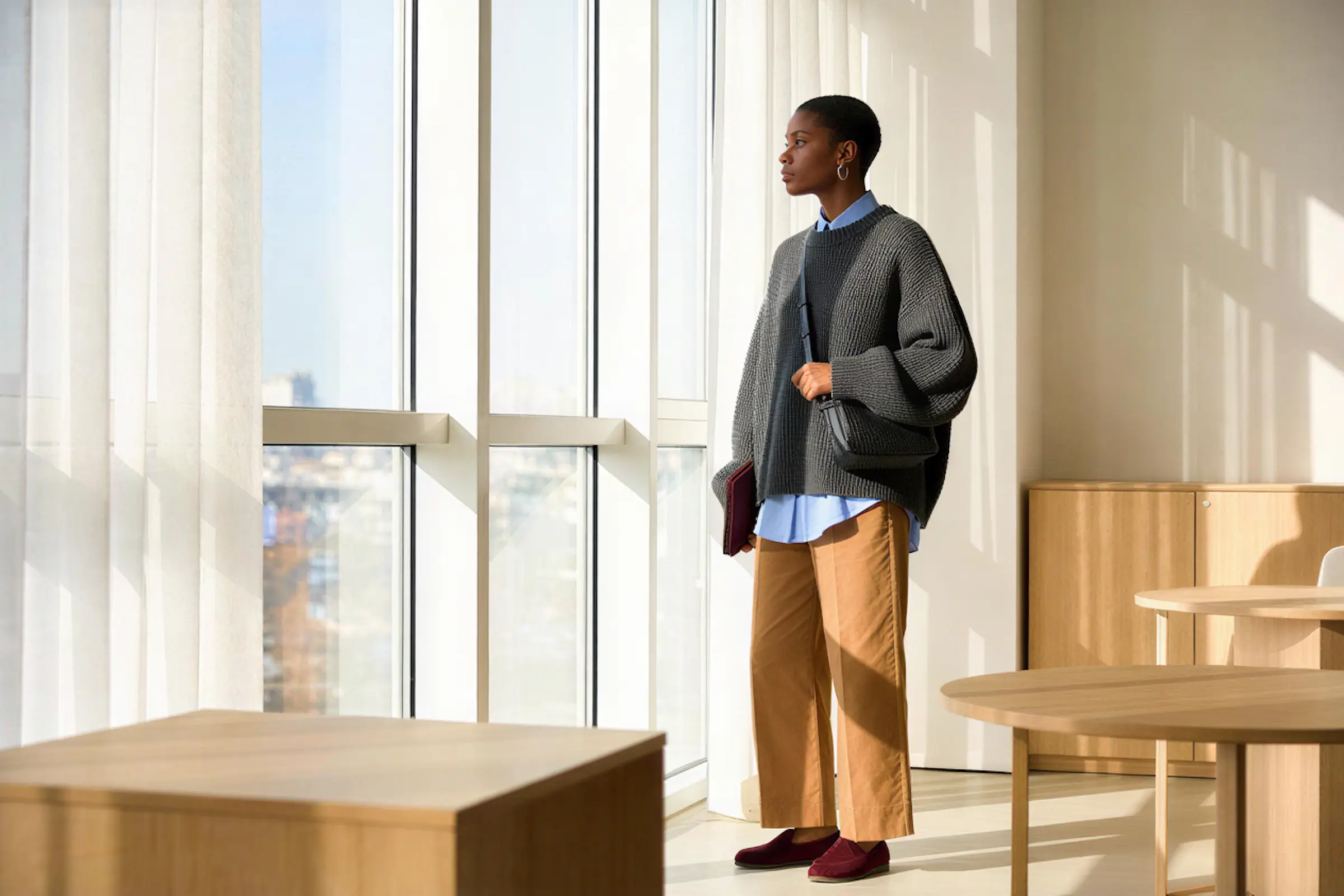 Person standing in a modern interior space with boxes, suggesting moving or setup