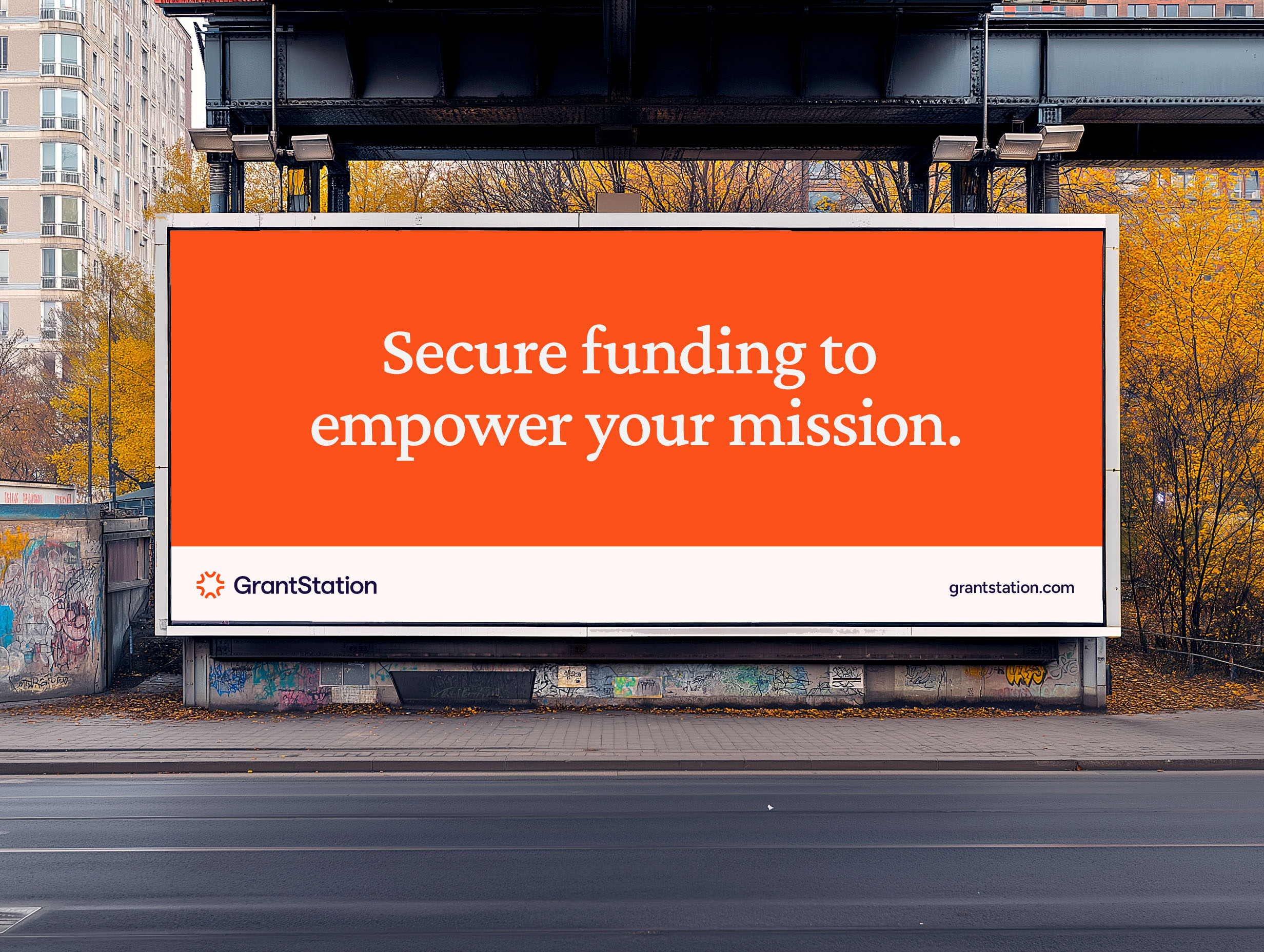 Large outdoor billboard with orange background and the message “Secure funding to empower your mission.”